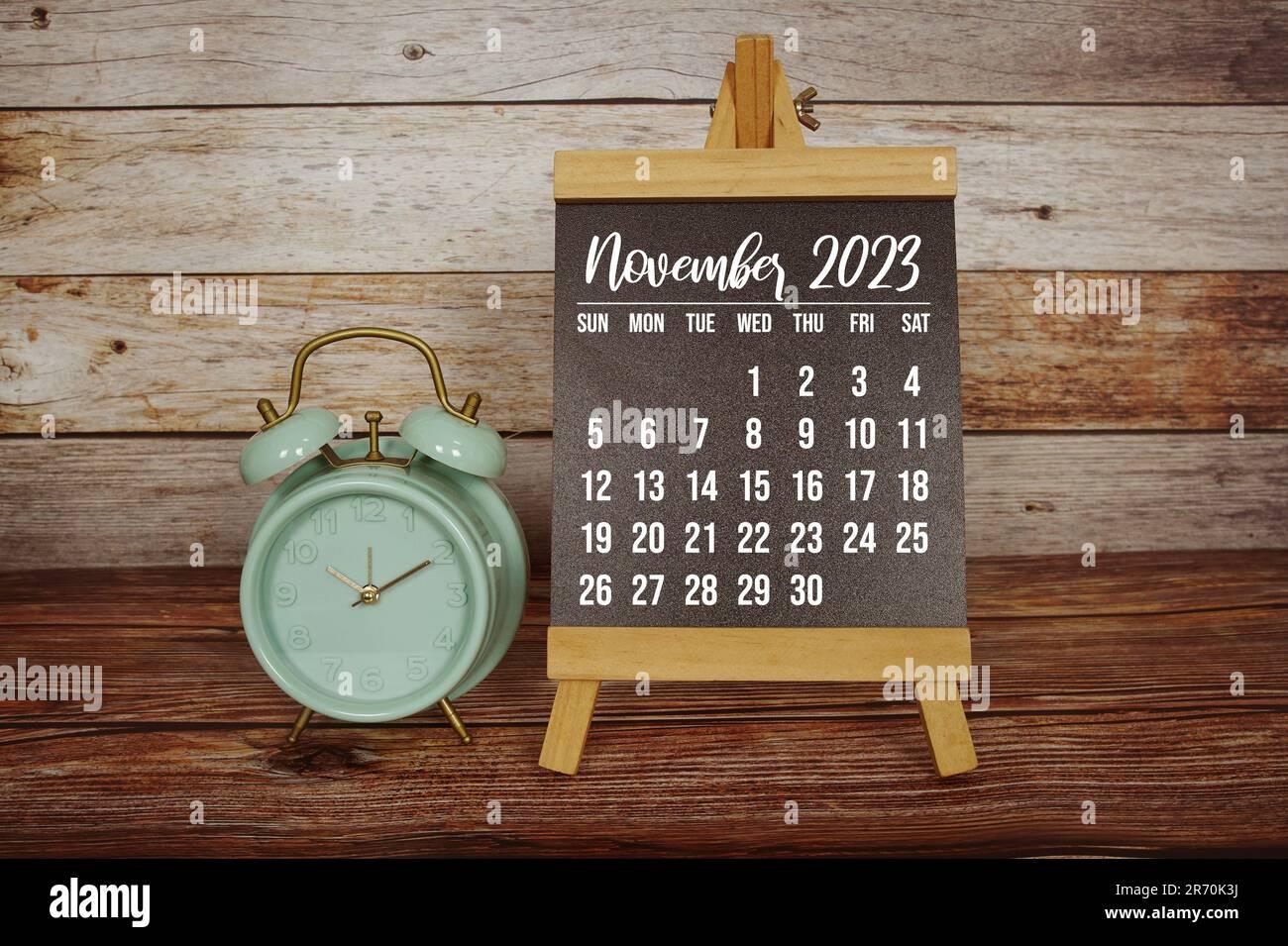 November Monthly Calendar And Alarm Clock On Wooden