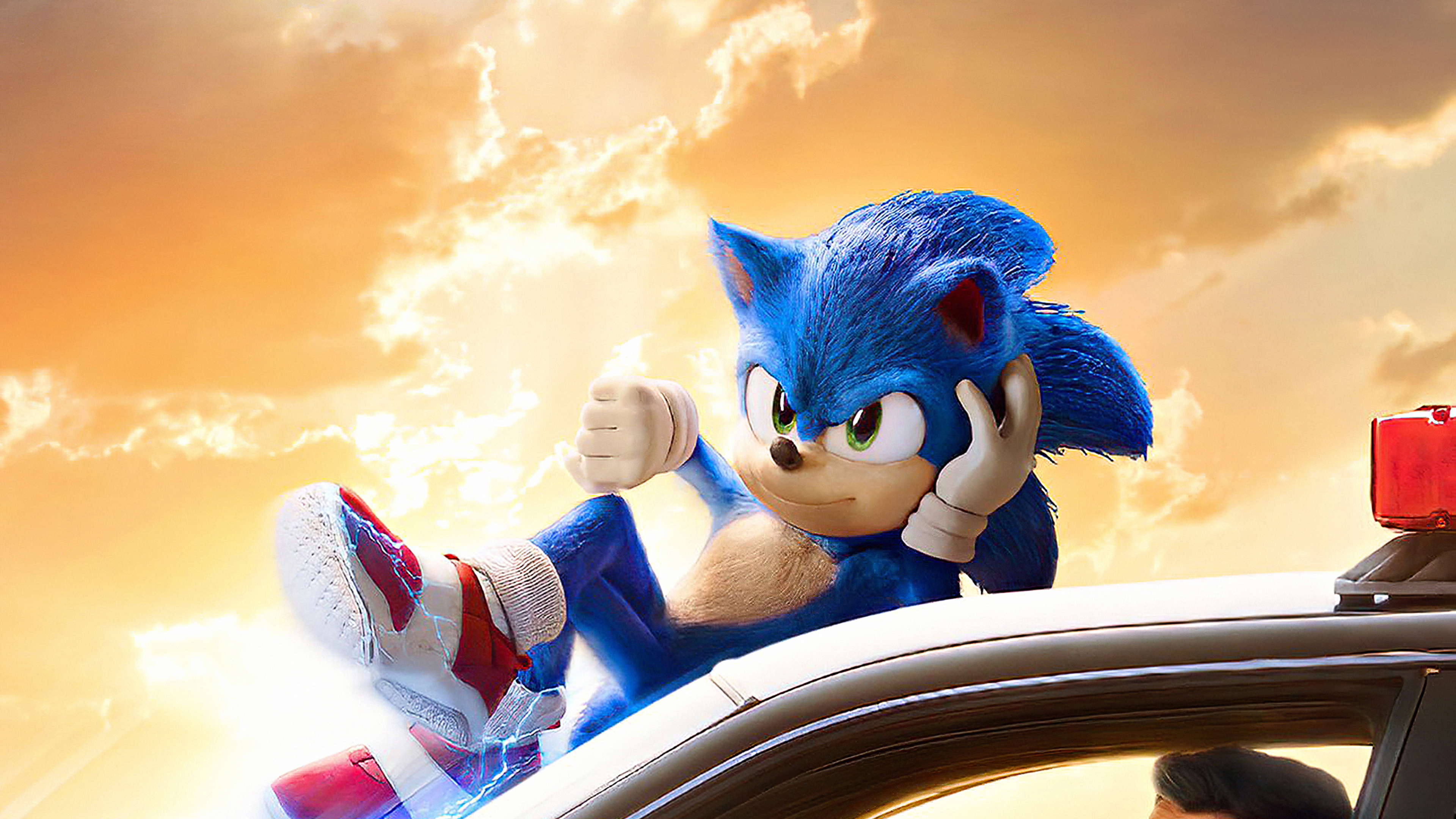 Sonic the Hedgehog relaxing on a police car against a sunset backdrop