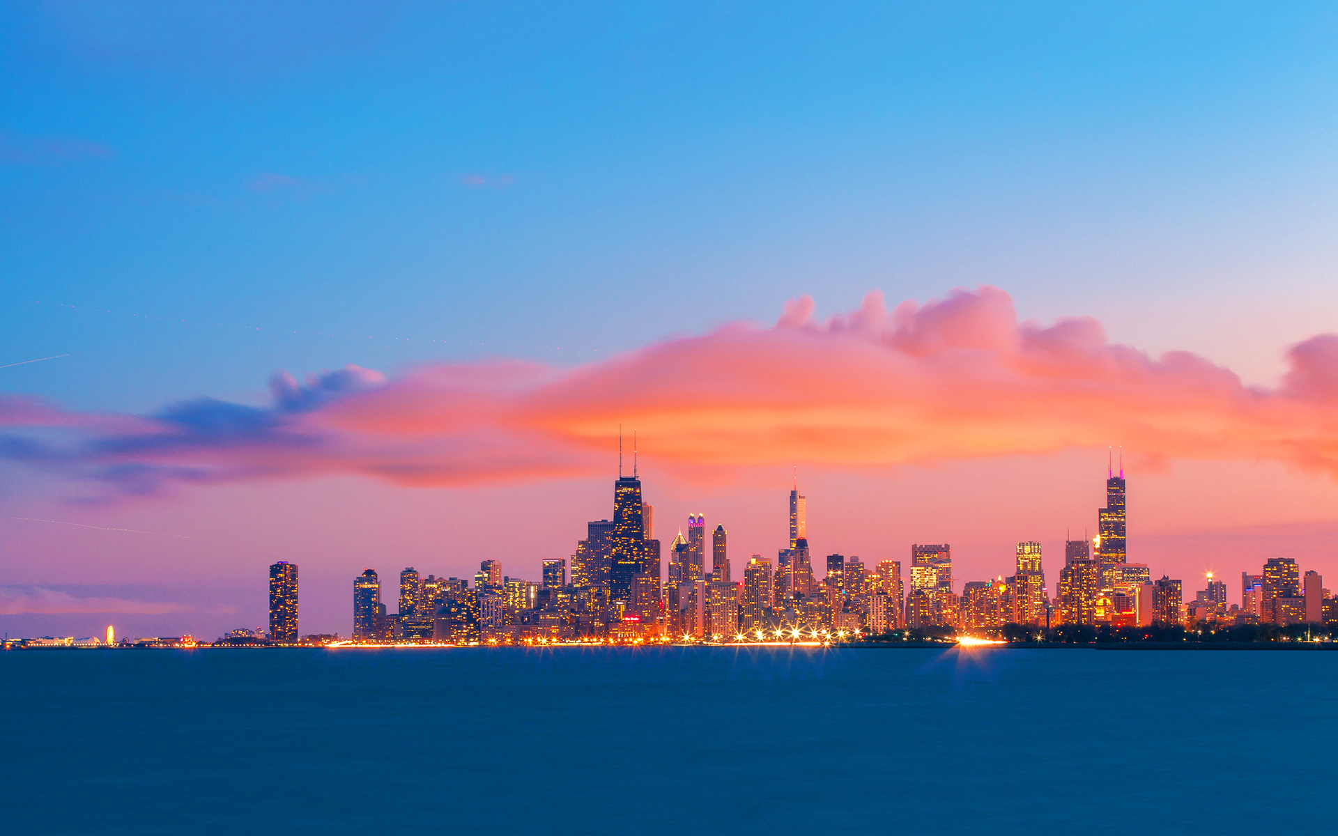 Chicago skyline at sunset with colorful clouds reflecting in the water of Lake Michigan