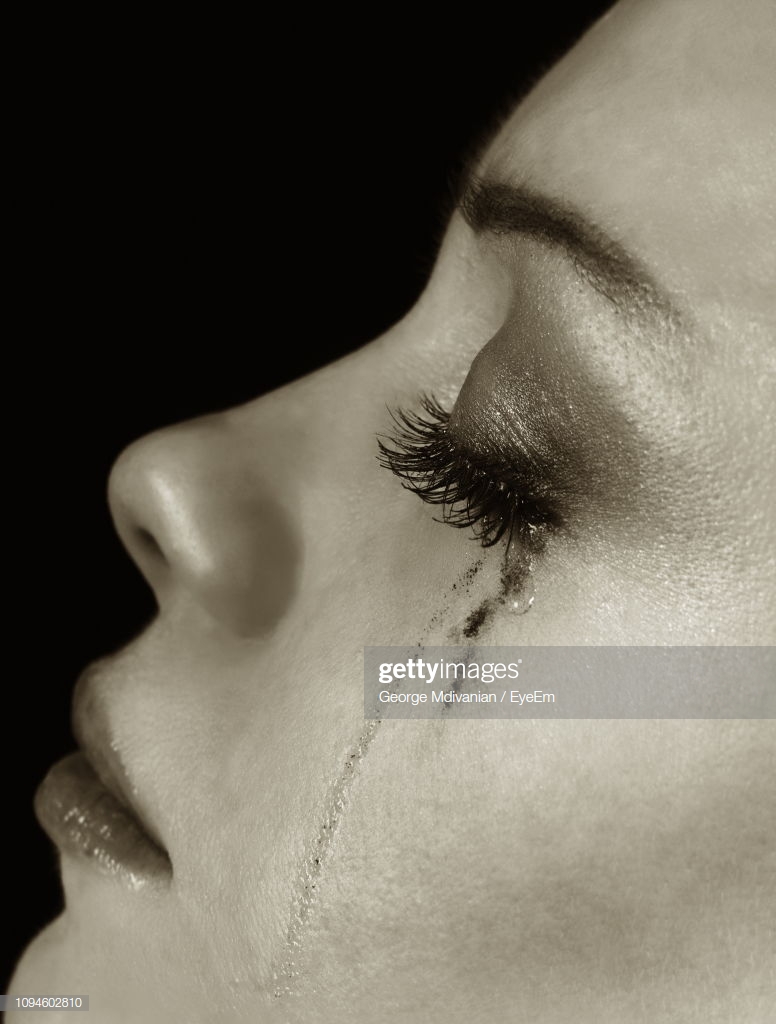 Closeup Side Of Young Woman With Smudged Makeup Crying