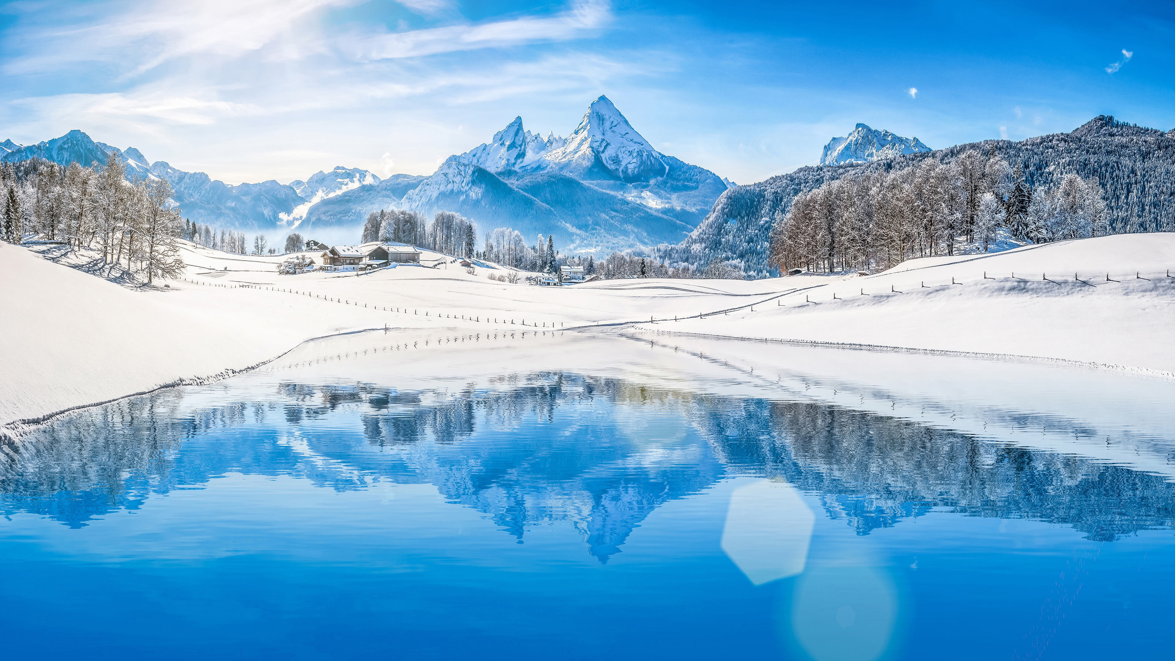 Stunning 4K winter landscape with snow-capped mountains reflecting in a crystal-clear lake