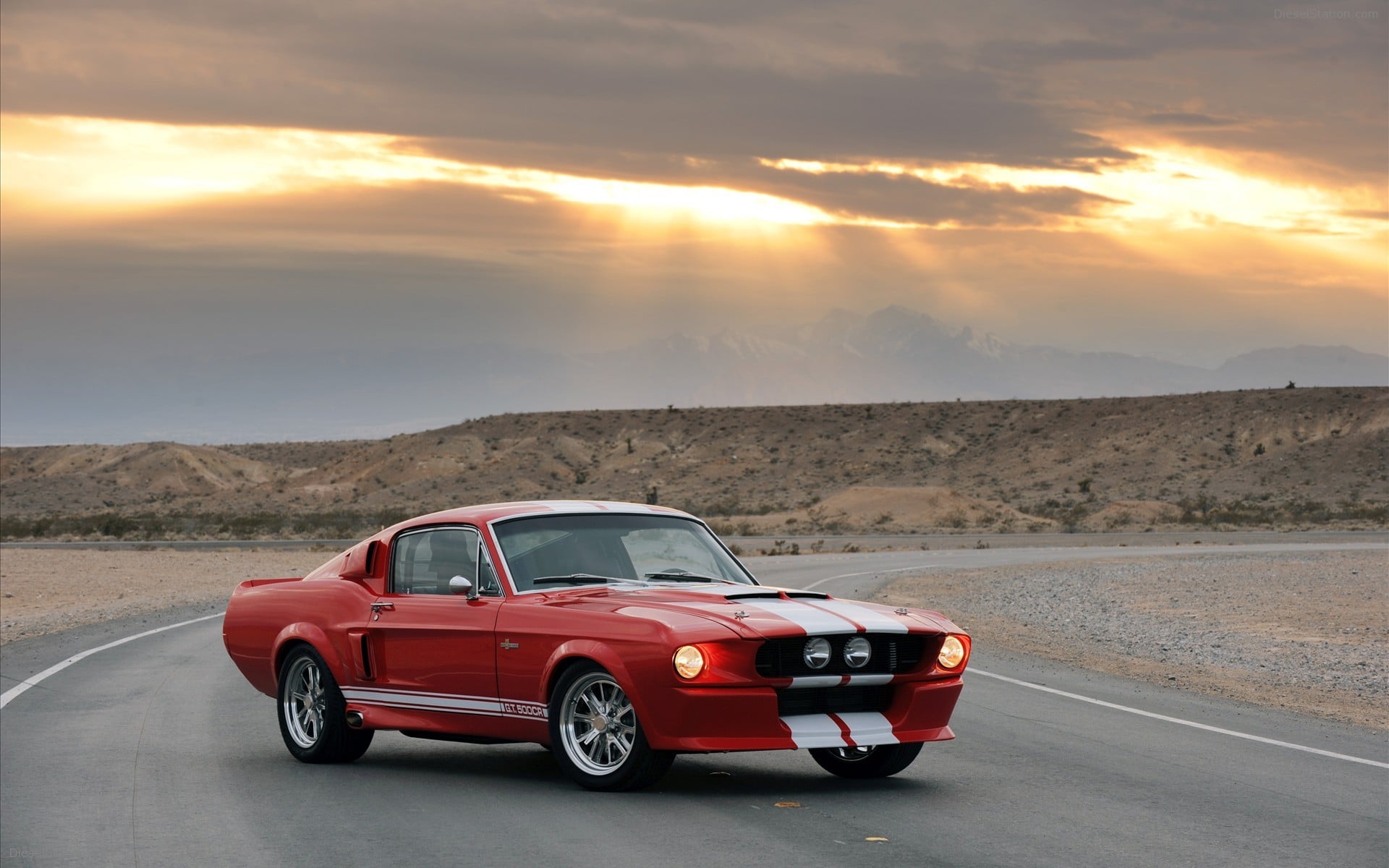 Red Ford Mustang Shelby GT500 on a desert road at sunset