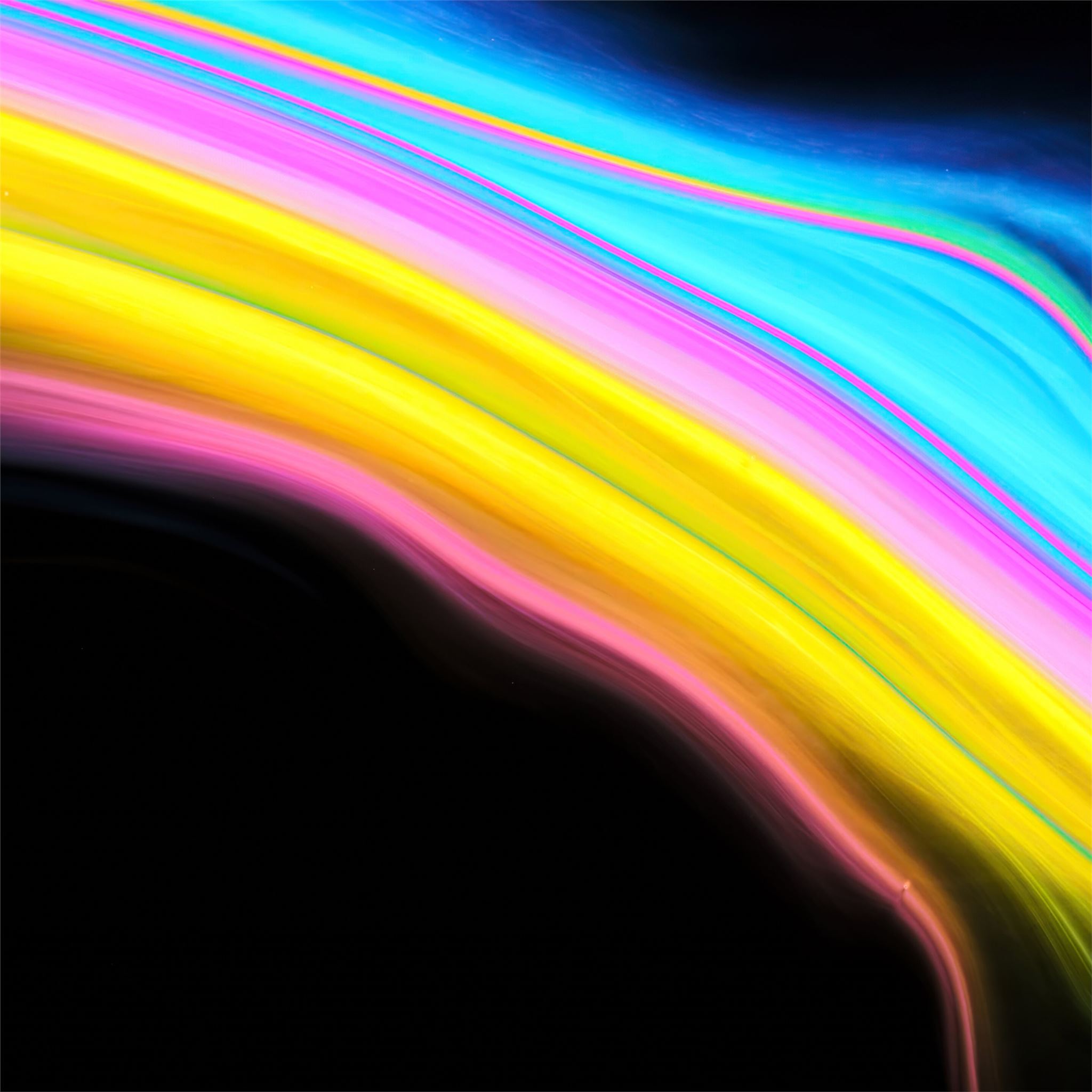 Abstract background with swirling, vibrant colors of pink, yellow, blue, and black, resembling a rainbow or oil slick