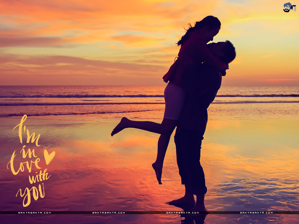 Silhouette of a couple embracing on a beach at sunset, with the text 'I'm in love with you' overlaid