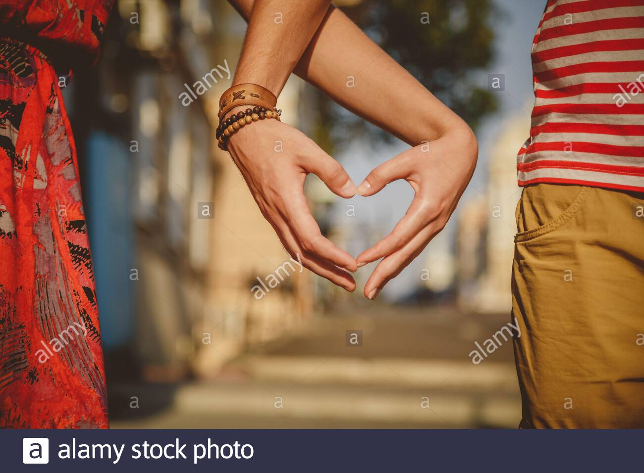 Close Up Of Loving Couple Making Heart Shape With Hands At City