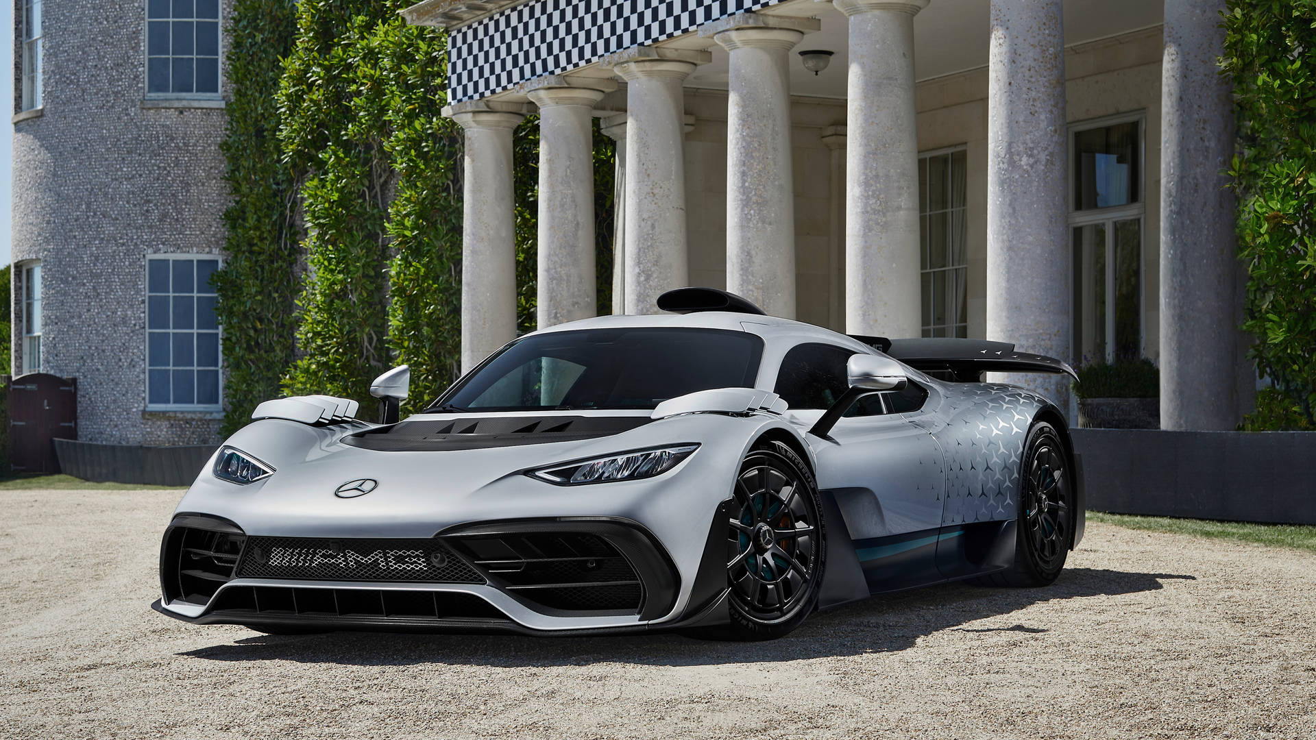 A silver Mercedes-AMG One hypercar parked in front of a grand building