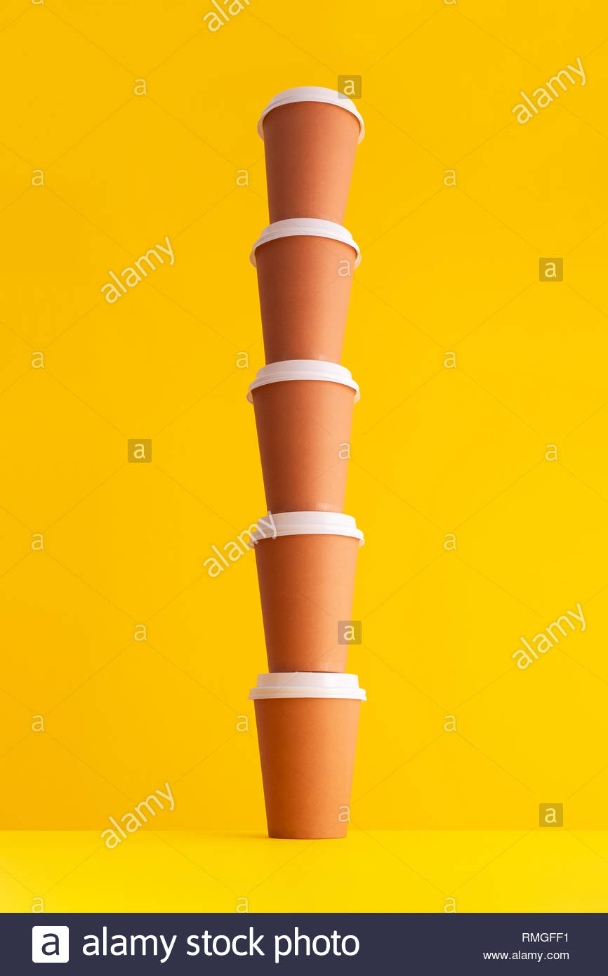 Multiple Disposable Coffee Cups Organized In A Stack Over Yellow