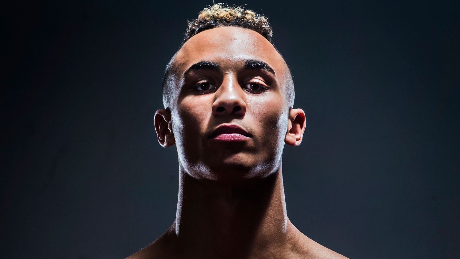Close-up portrait of boxer Benjamin Whittaker against a dark background