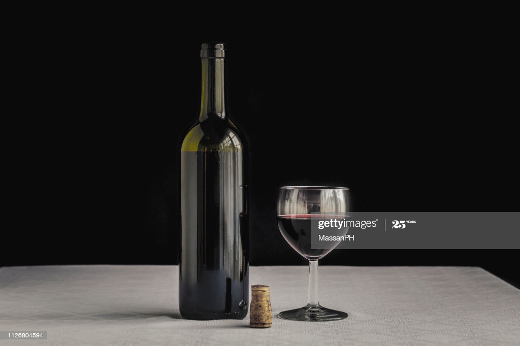 Bordeaux Bottle On White Tablecloth And Black Background Next To A