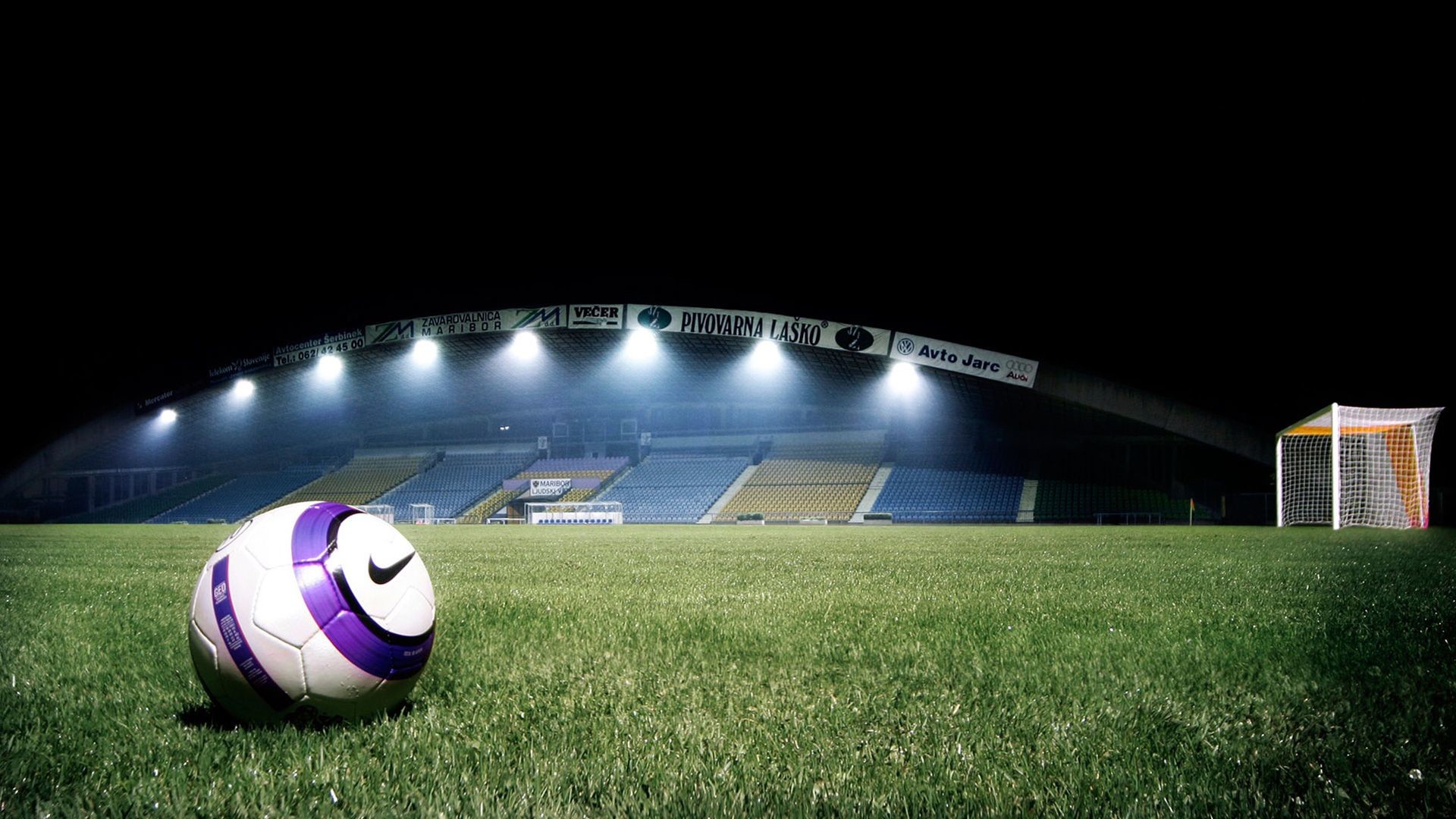 Nike Football on a Lush Green Field at Night