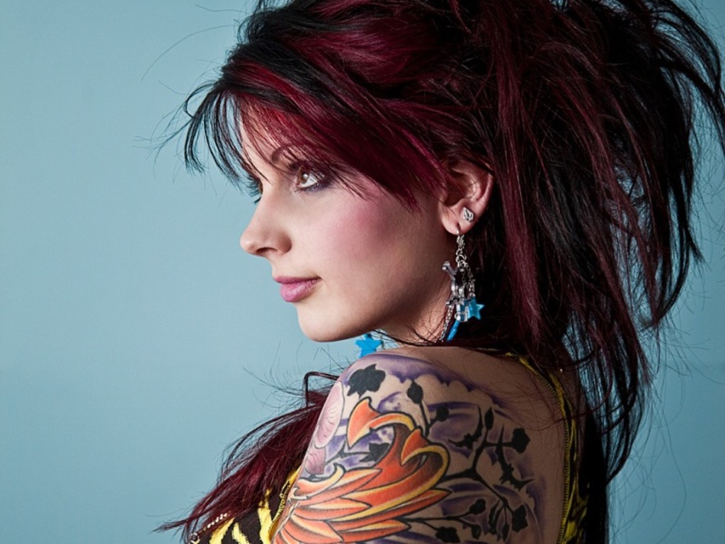 Woman with colorful shoulder tattoo and dark red hair