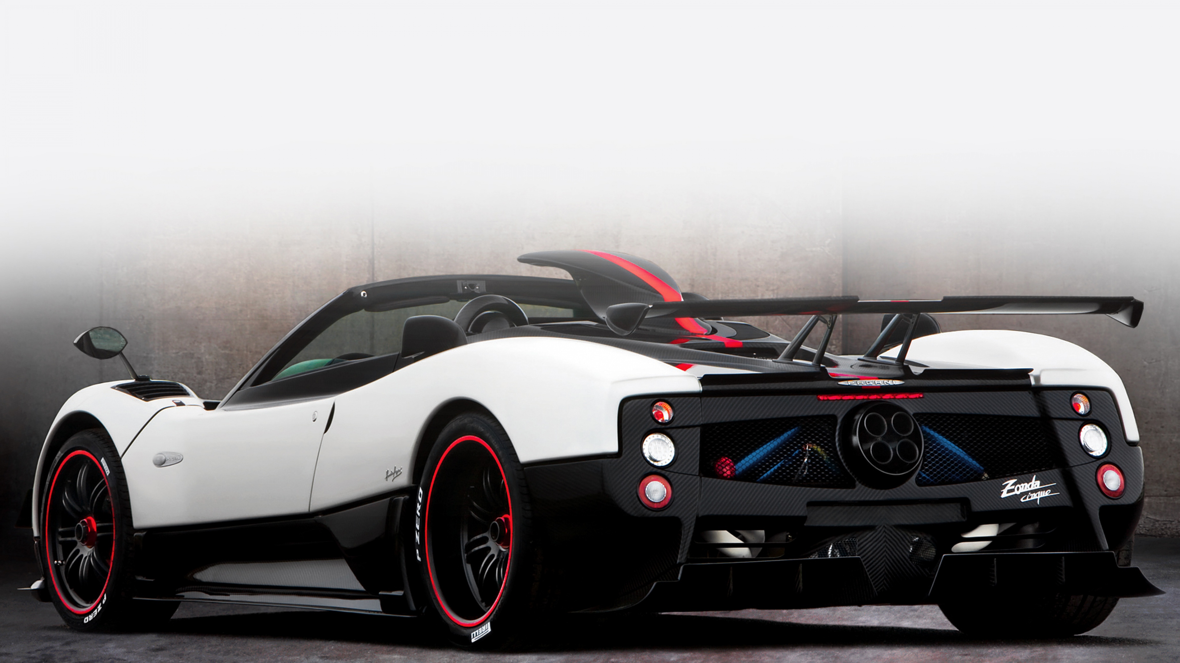 A rear view of a white and black Pagani Zonda Cinque Roadster, highlighting its unique design and powerful engine
