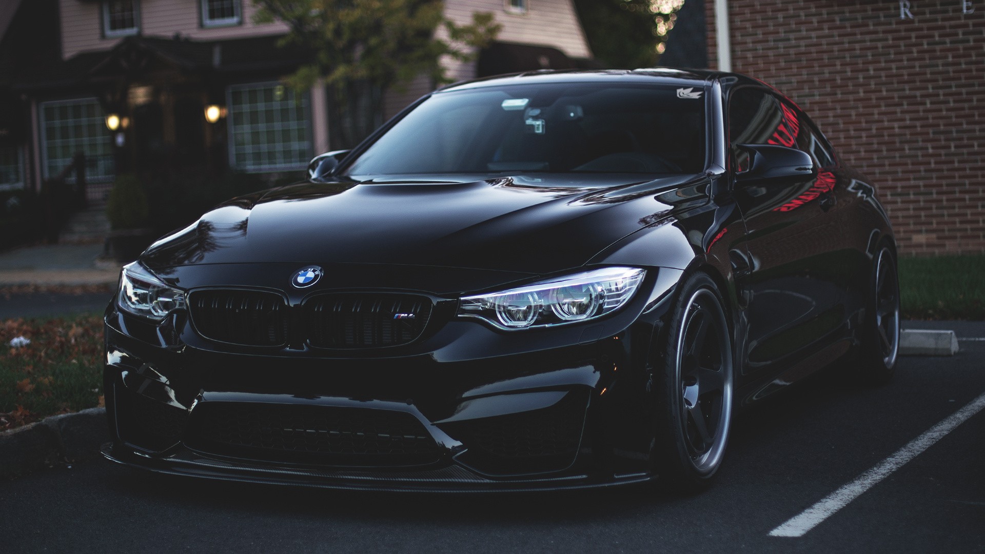 Sleek black BMW M4 parked in front of a building