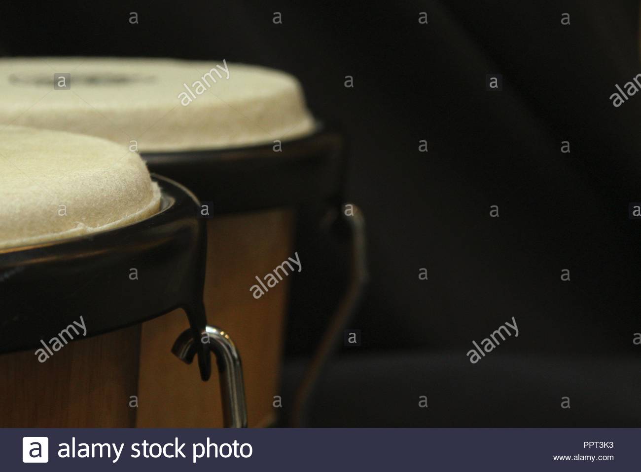 Free download pair of bongos from the left side against a dark