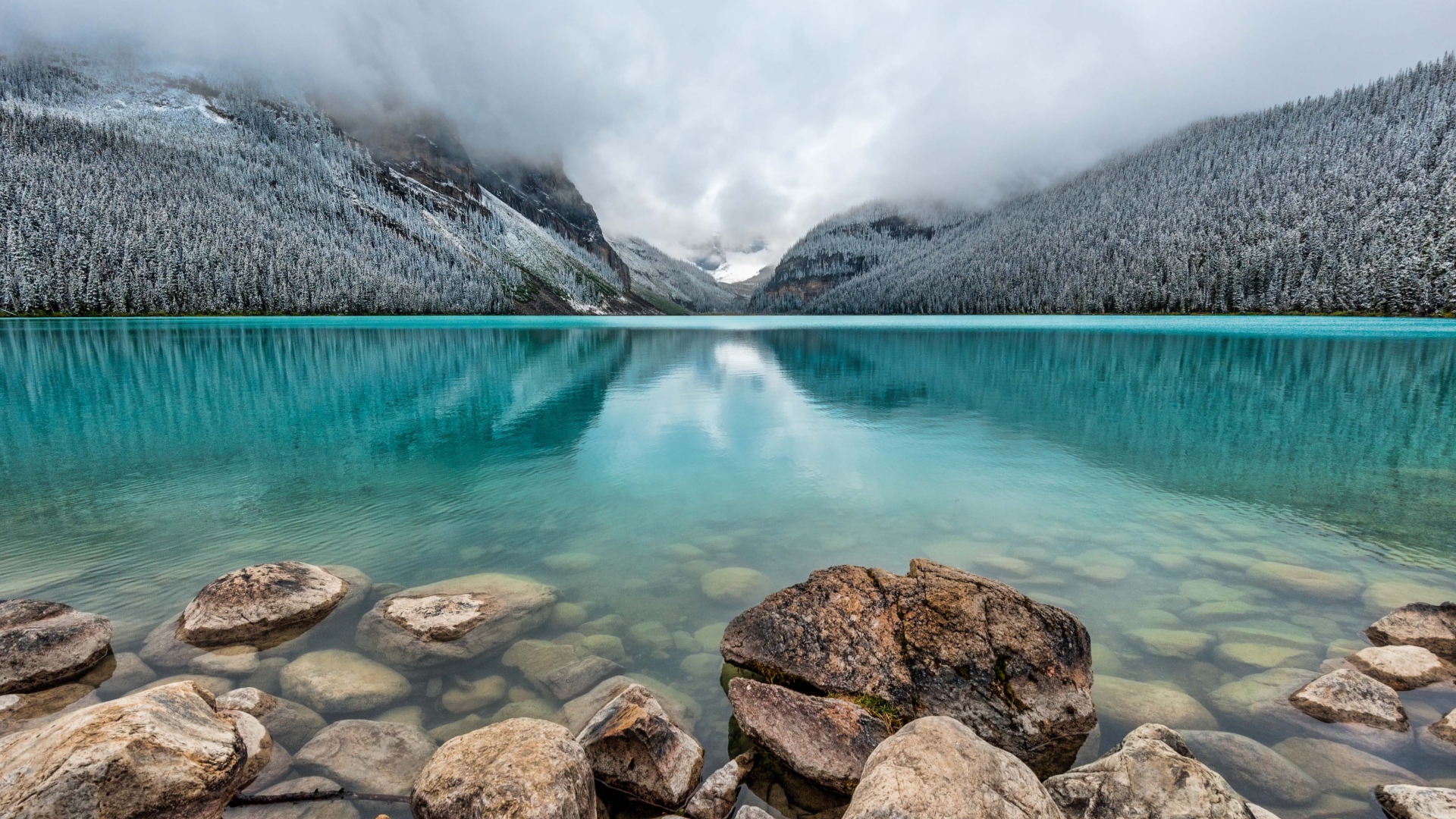 Serene turquoise lake reflecting snow-dusted mountains, perfect for a desktop wallpaper
