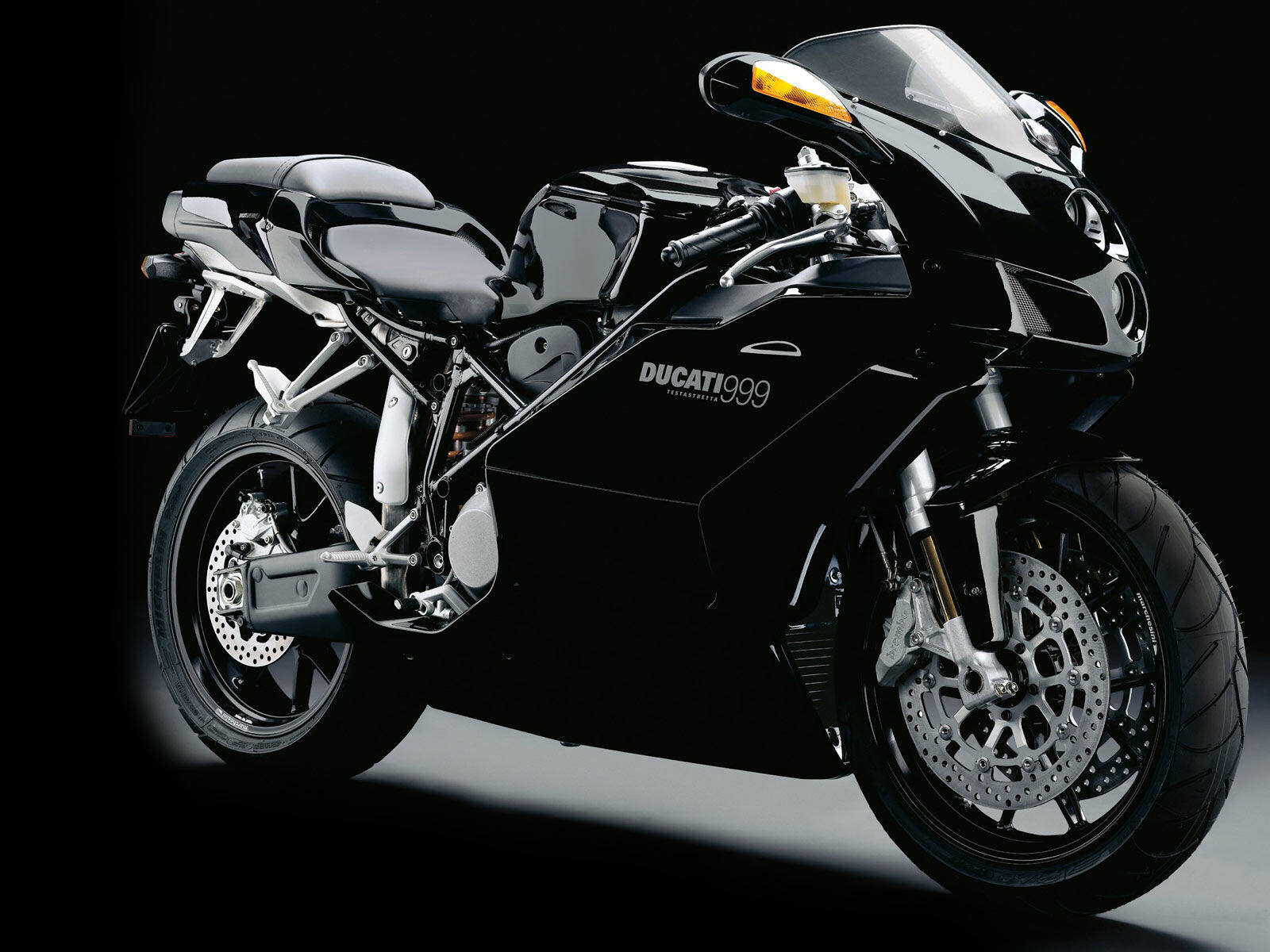 A sleek black Ducati 999 motorcycle against a dark background