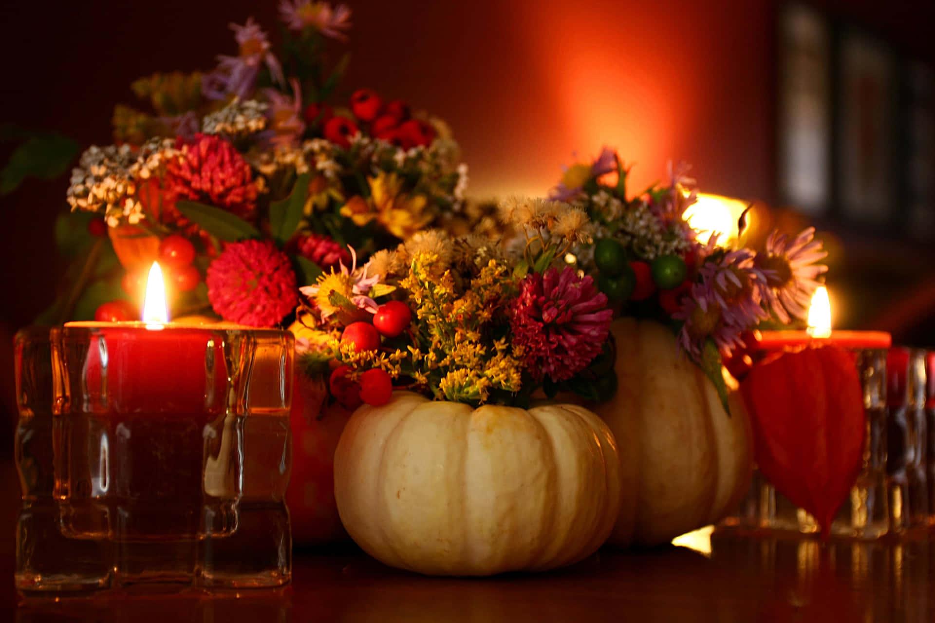 A Table With Candles And Flowers Wallpaper