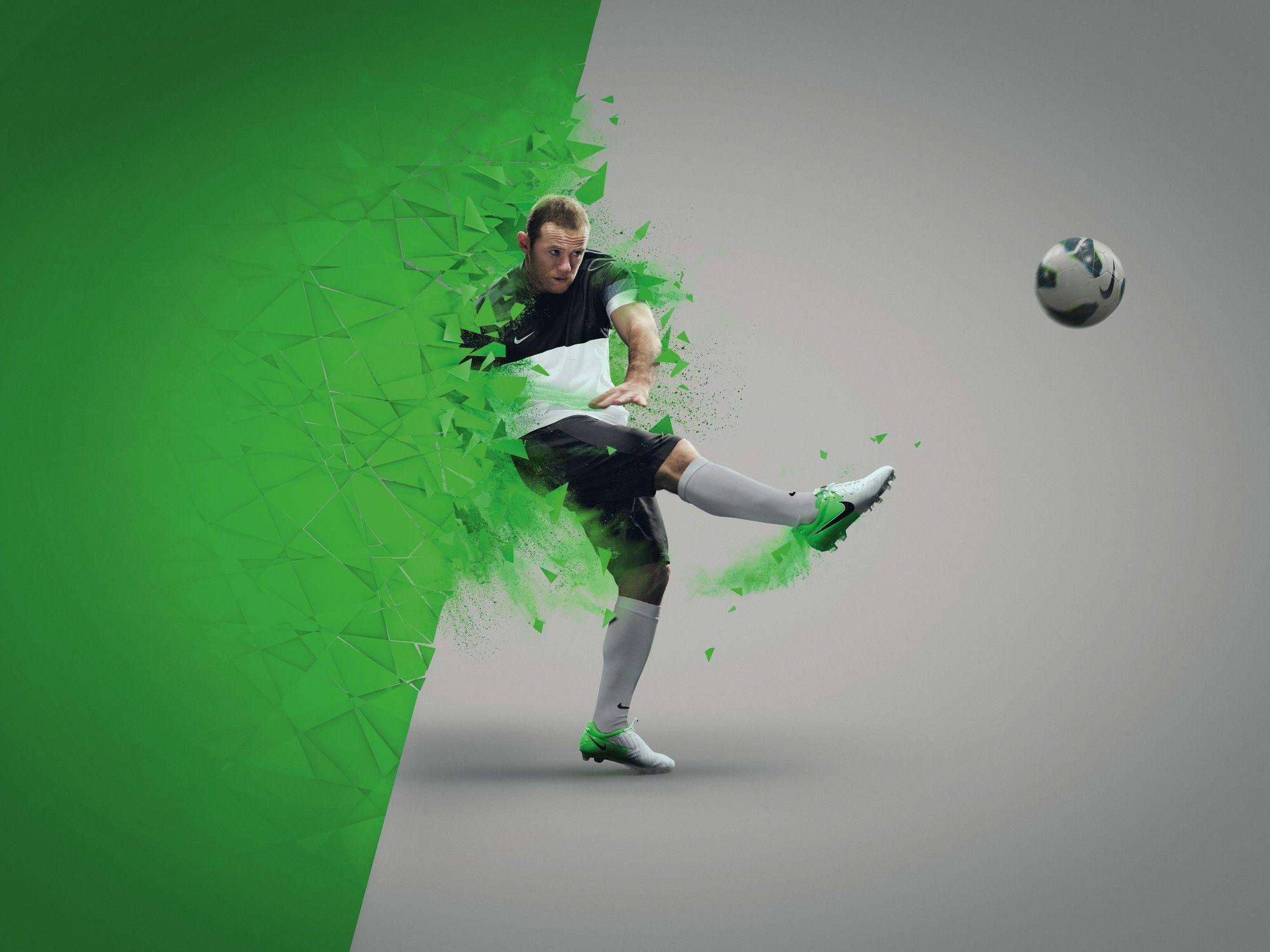 A football player wearing Nike apparel kicks the ball mid-air, surrounded by a dynamic explosion of green shards
