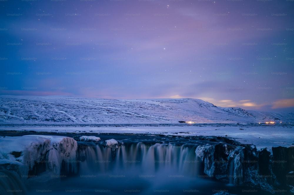 A Frozen Waterfall In The Middle Of Snowy Landscape Photo