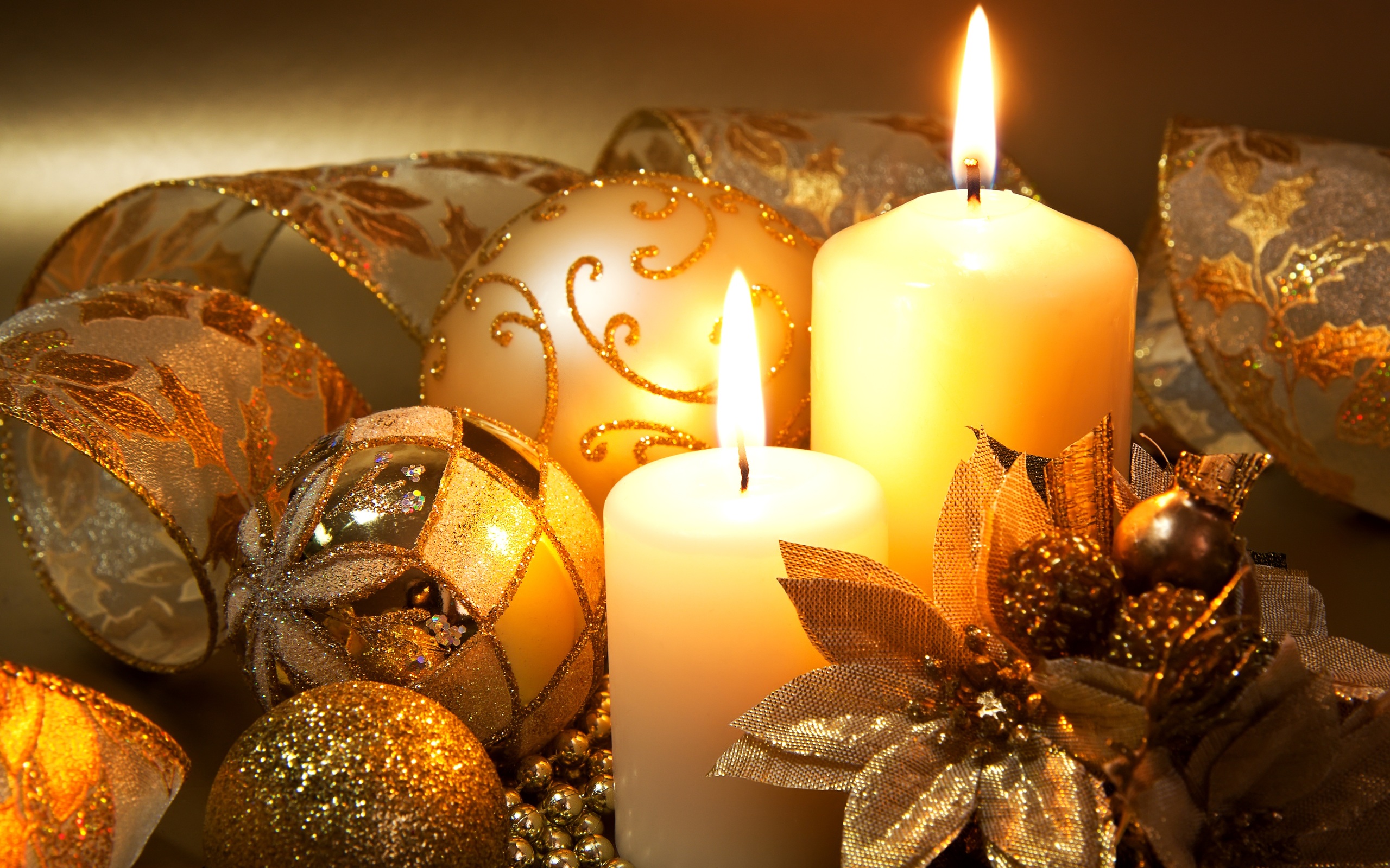 Elegant Christmas still life with candles, ornaments, and ribbons in gold and white tones