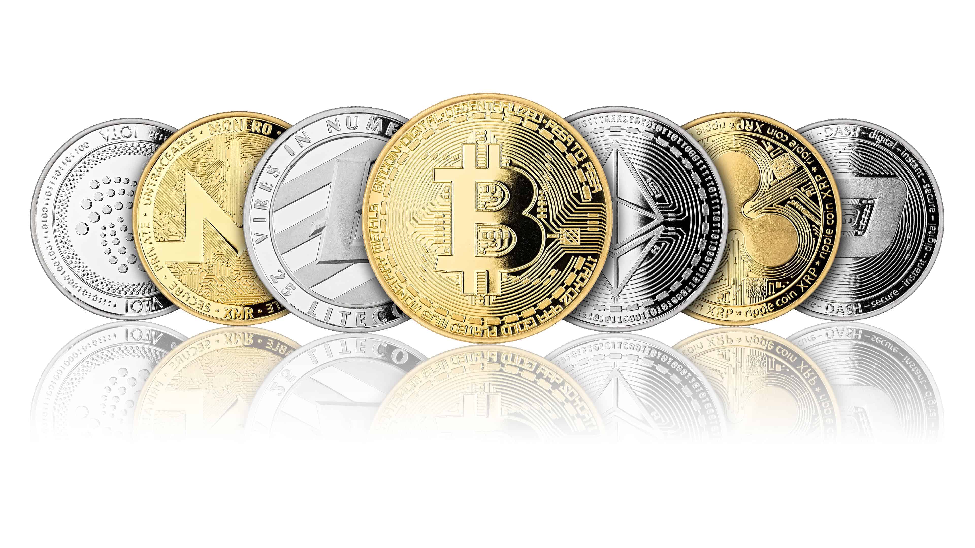 A collection of various cryptocurrency coins, including Bitcoin, Ethereum, Litecoin, Monero, Ripple, and Dash, arranged in a row with their reflections