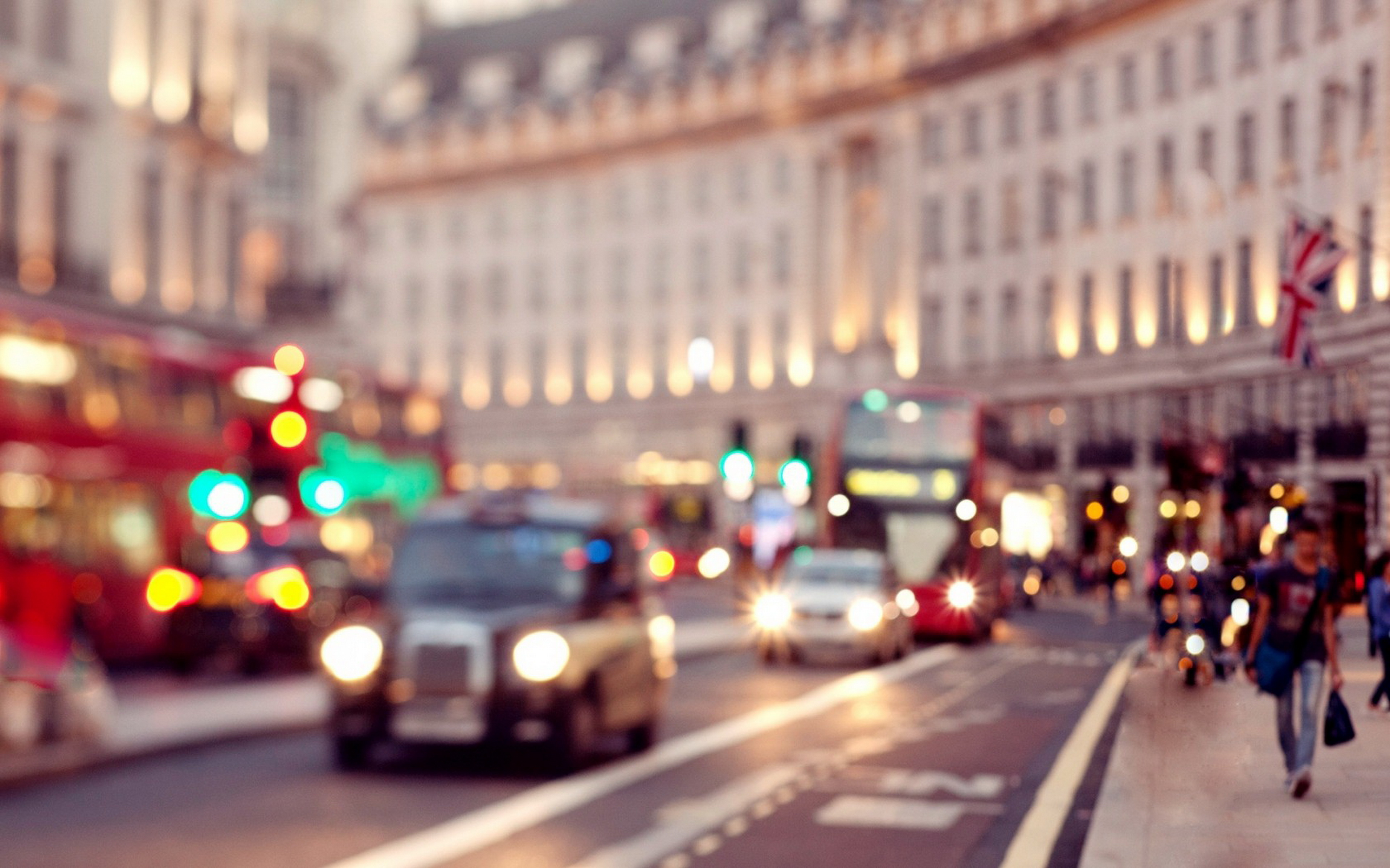 Blurred image of London street with red buses and black cabs in motion, showcasing the city's vibrant energy at dusk