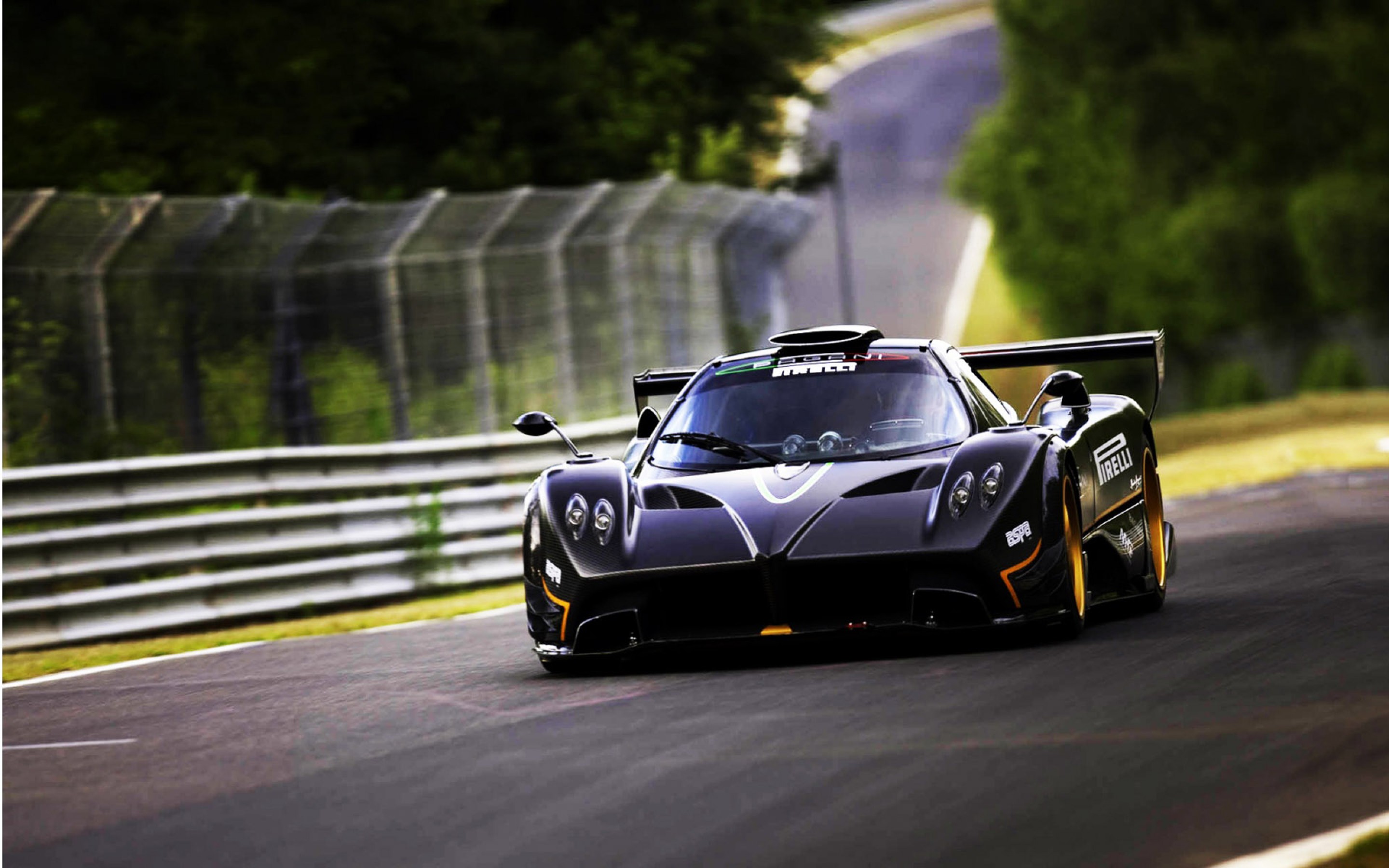 A sleek black Pagani Huayra supercar speeding on a race track