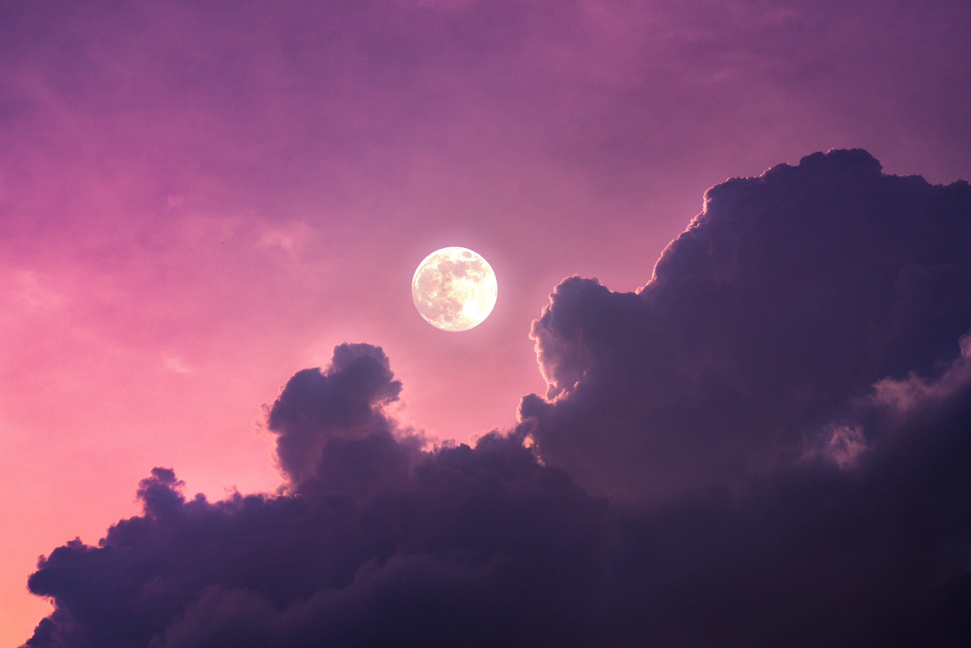 A breathtaking 4K wallpaper featuring a vibrant purple and pink sunset sky, with a bright full moon peeking through dark, dramatic clouds
