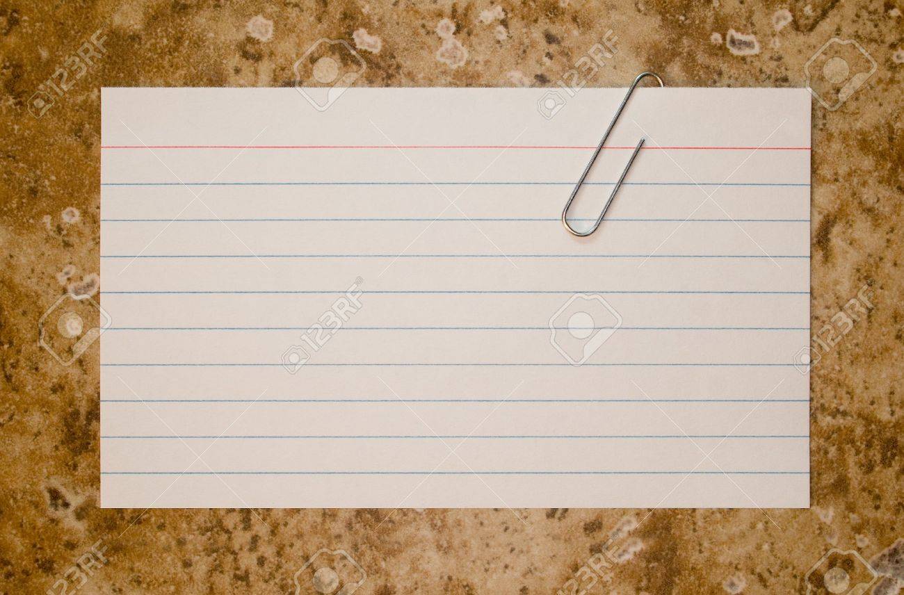 Single Lined Note Card And Paper Clip On Brown Stone Background
