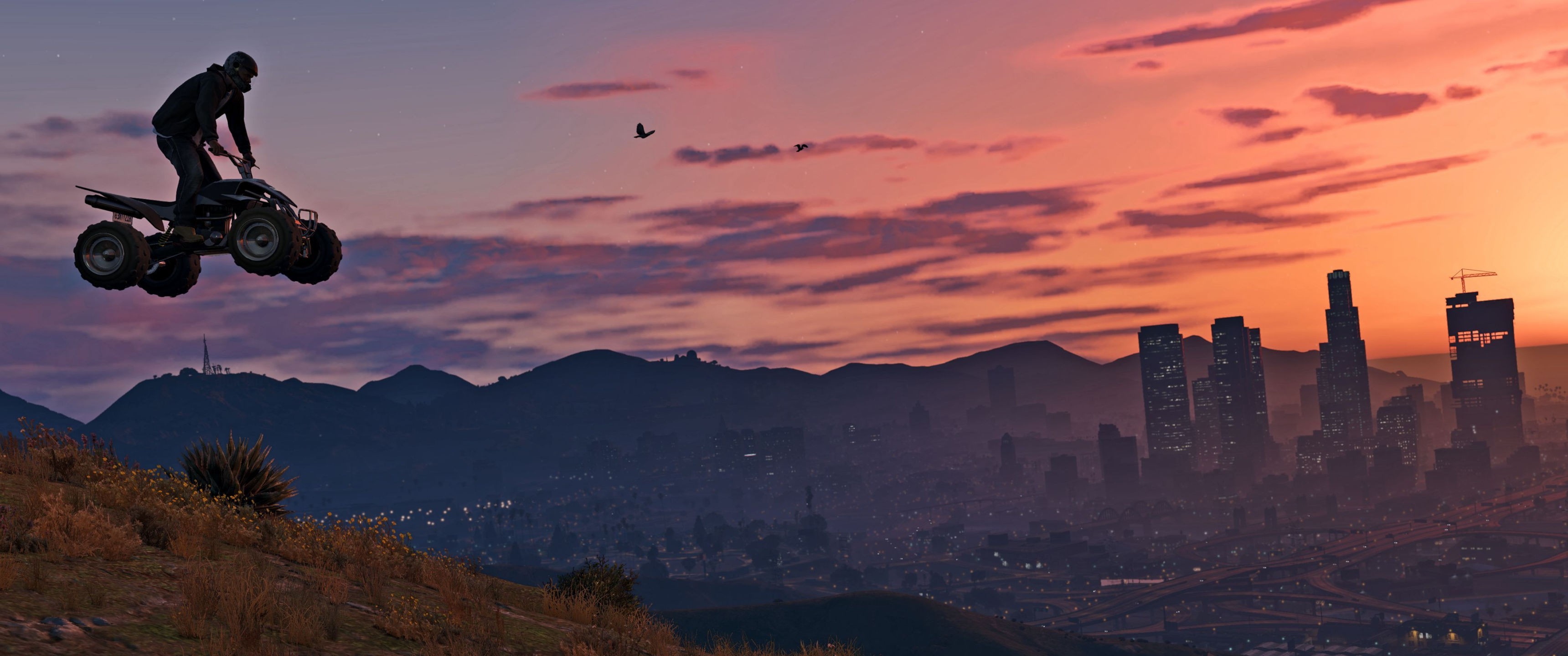 A quad bike soars over the Los Santos skyline at sunset in Grand Theft Auto V