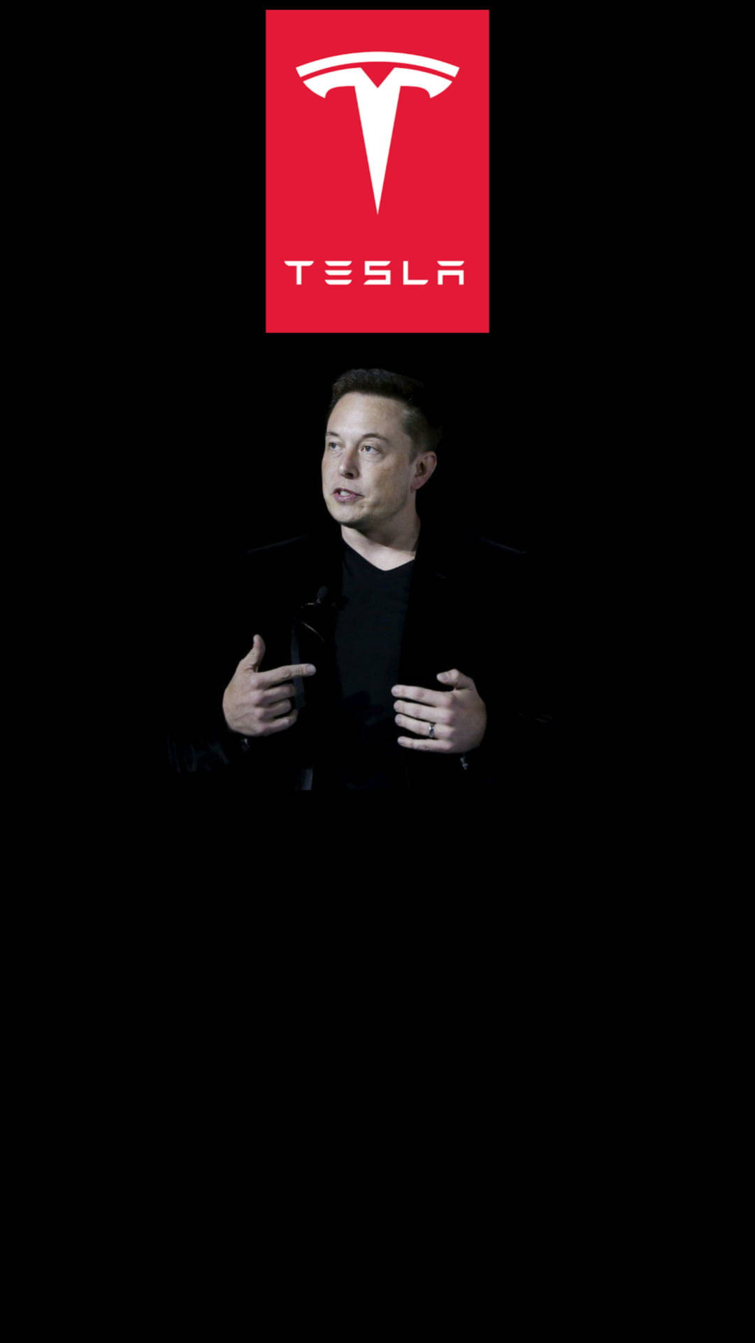 Elon Musk, CEO of Tesla, gesturing during a presentation in front of a Tesla logo