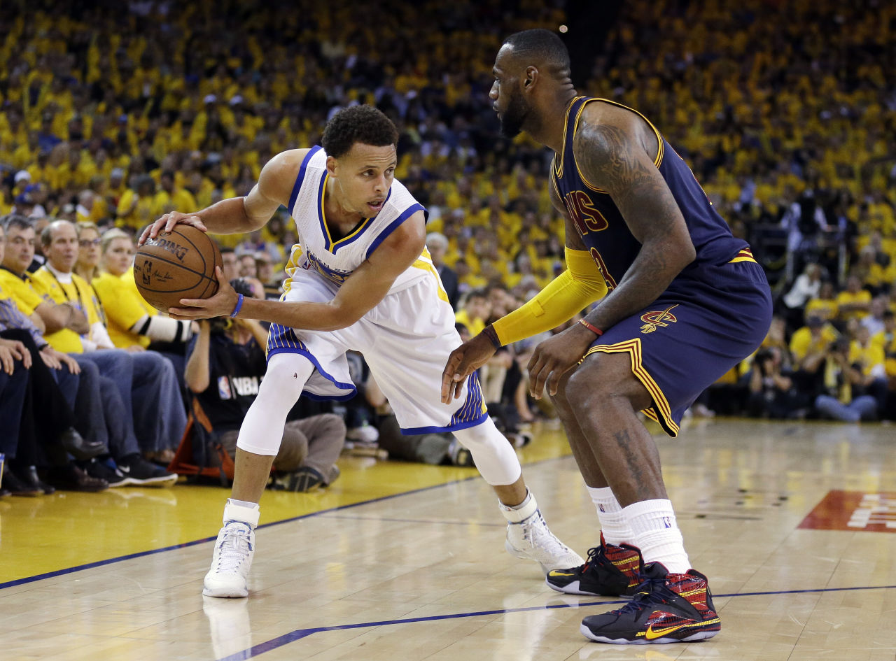 Stephen Curry of the Golden State Warriors dribbles the ball, guarded by LeBron James of the Cleveland Cavaliers, during the 2015 NBA Finals
