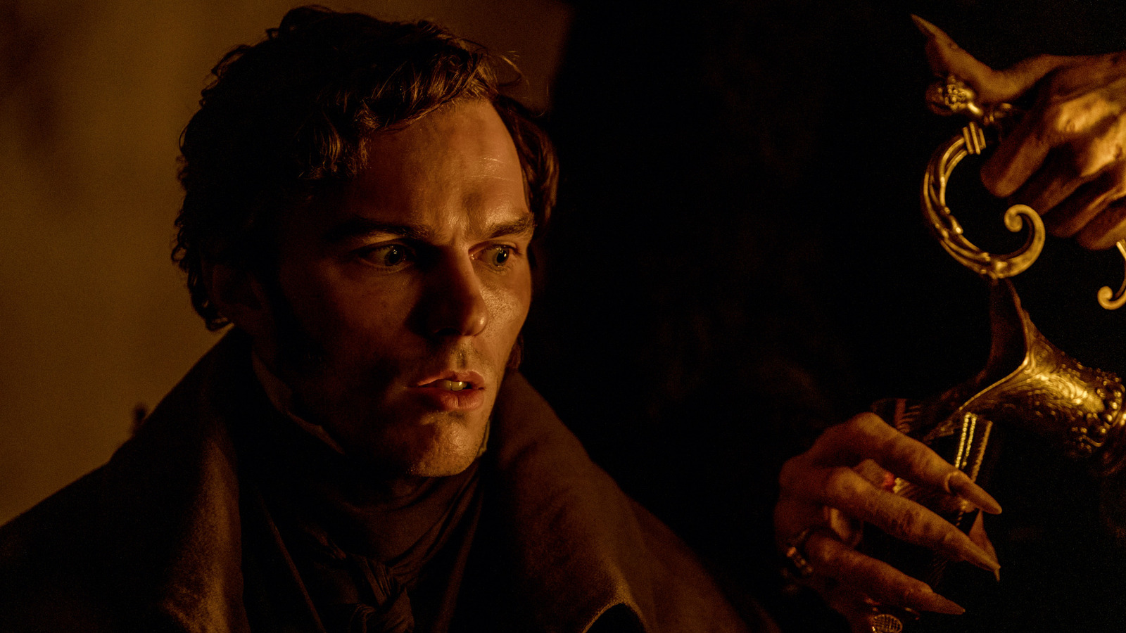 A man with a concerned expression in a dimly lit scene from Nosferatu 2024