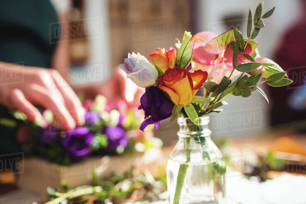 Close Up Of Flowers In Bottle While Female Florist Preparing