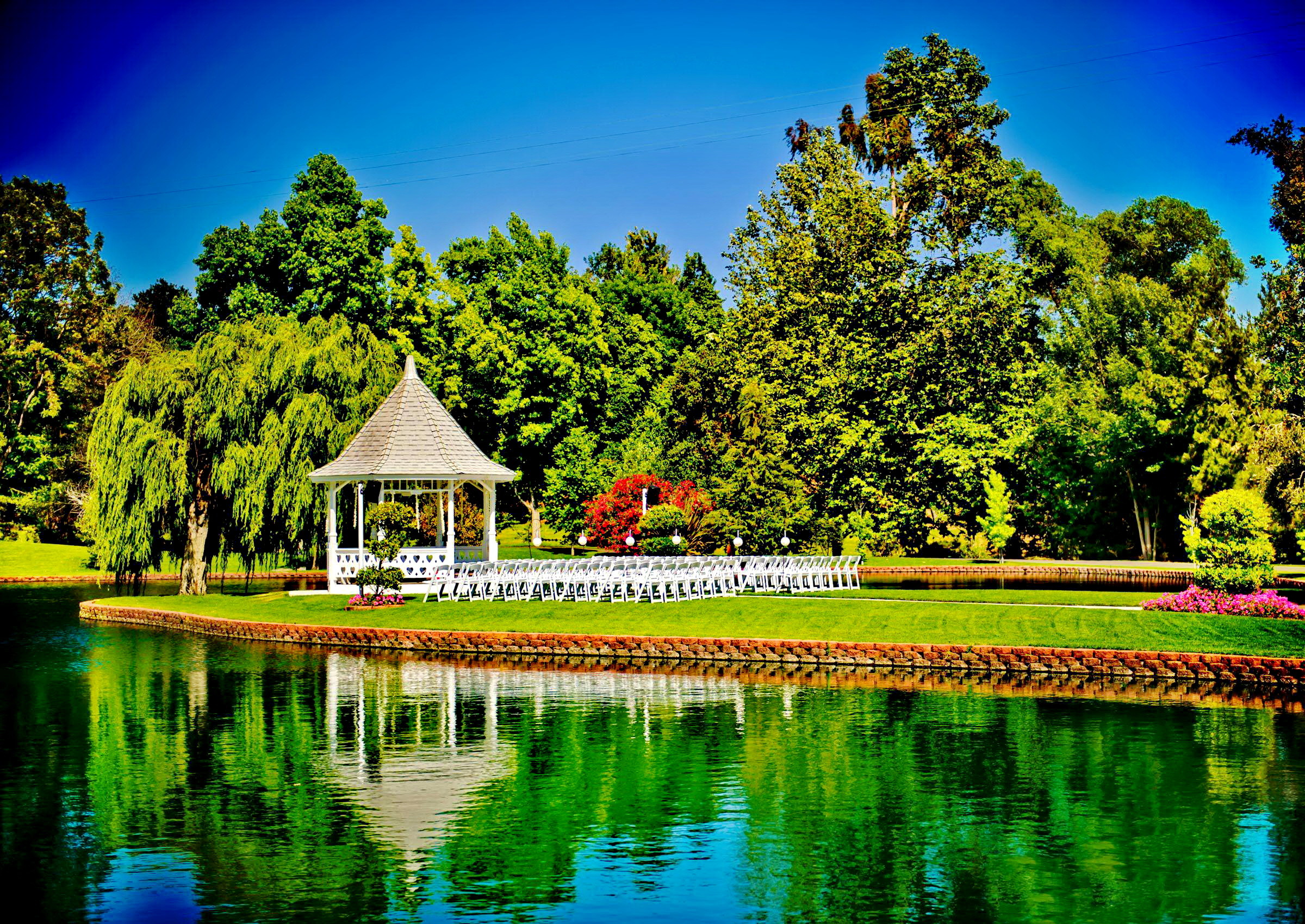 A serene summer landscape with a gazebo by the lake, perfect for a wedding or outdoor event