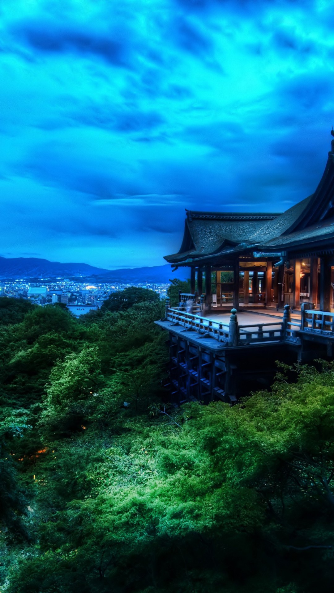A stunning night view of a Japanese temple overlooking a cityscape, illuminated by the twilight glow