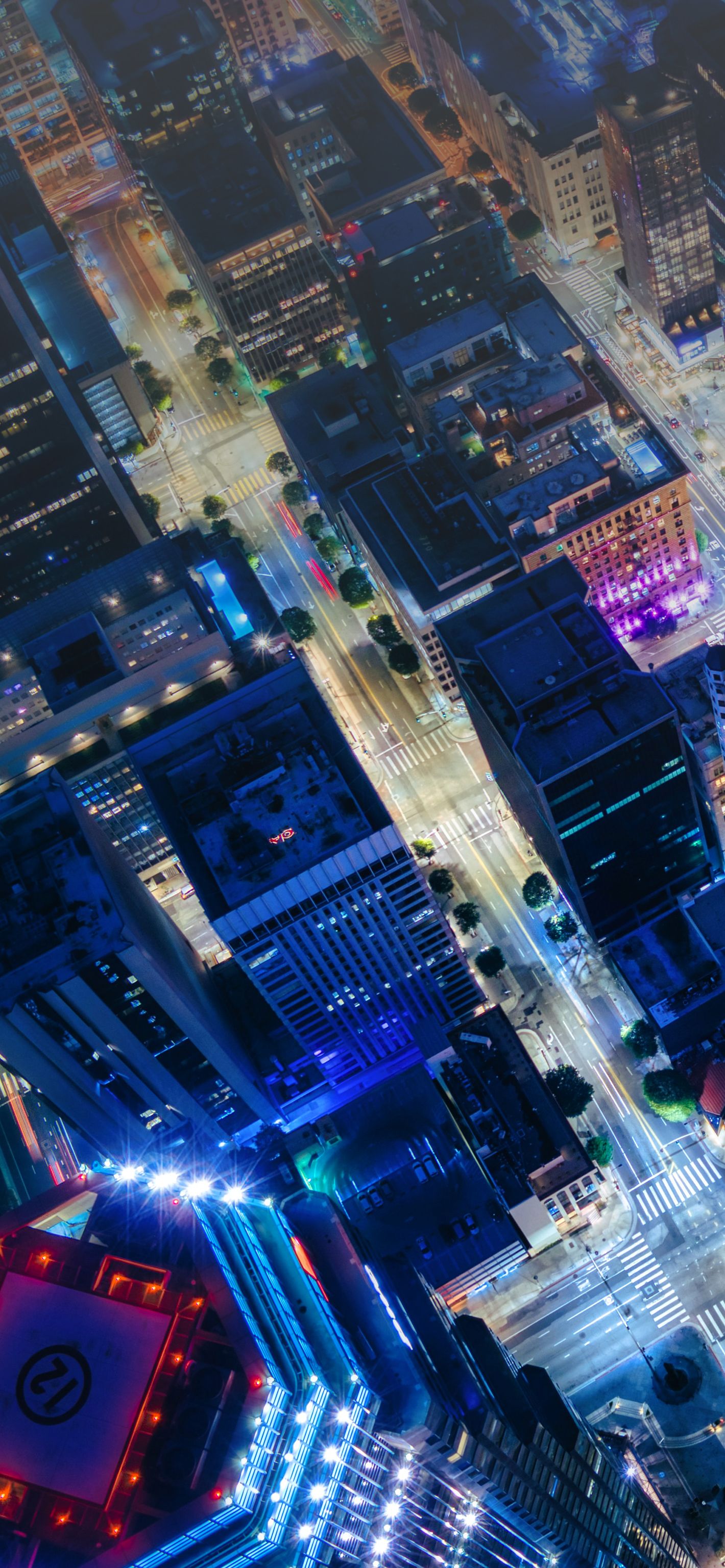 Aerial view of a city at night, illuminated by streetlights and building lights