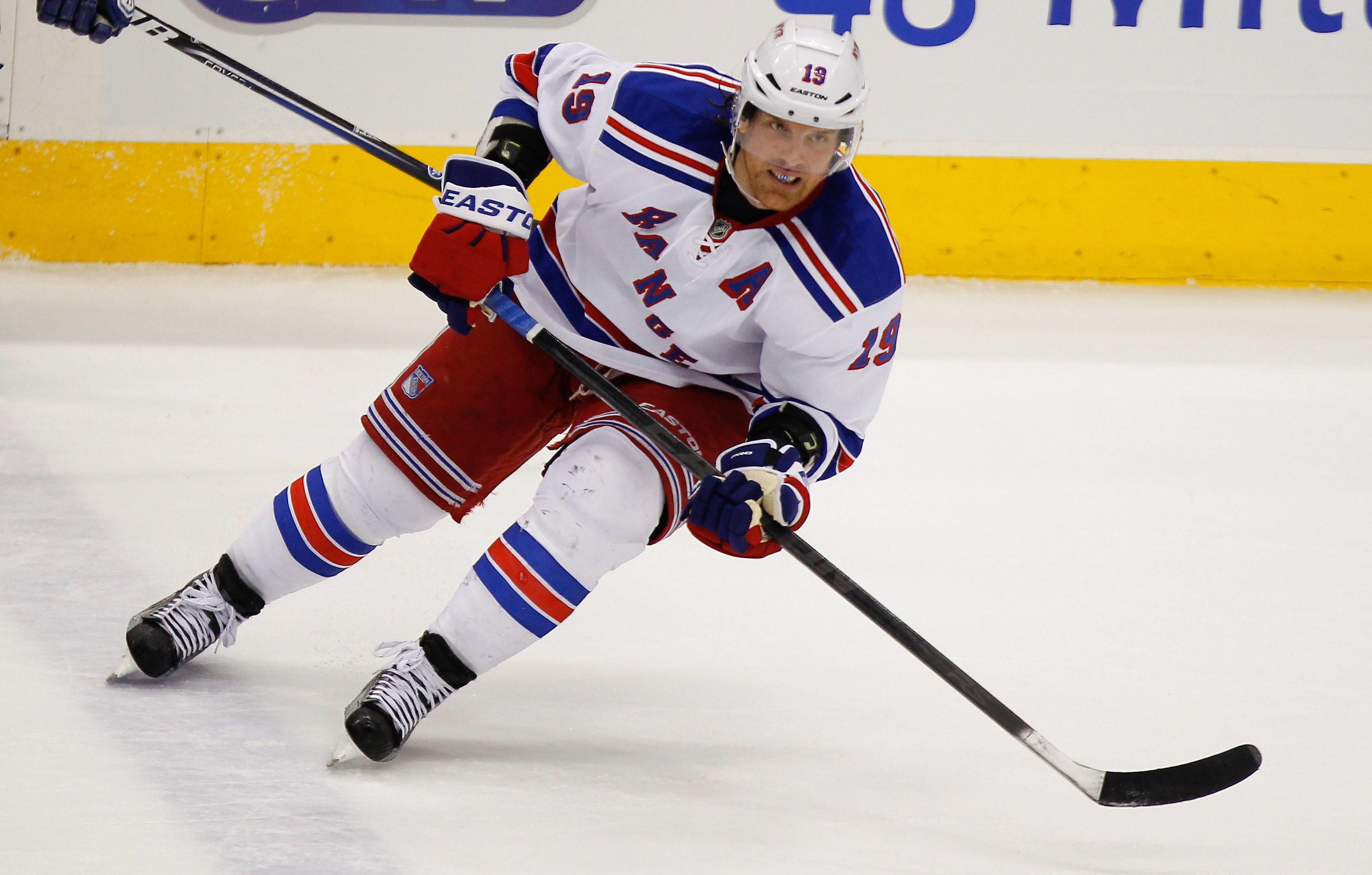New York Rangers player skates with the puck during a game