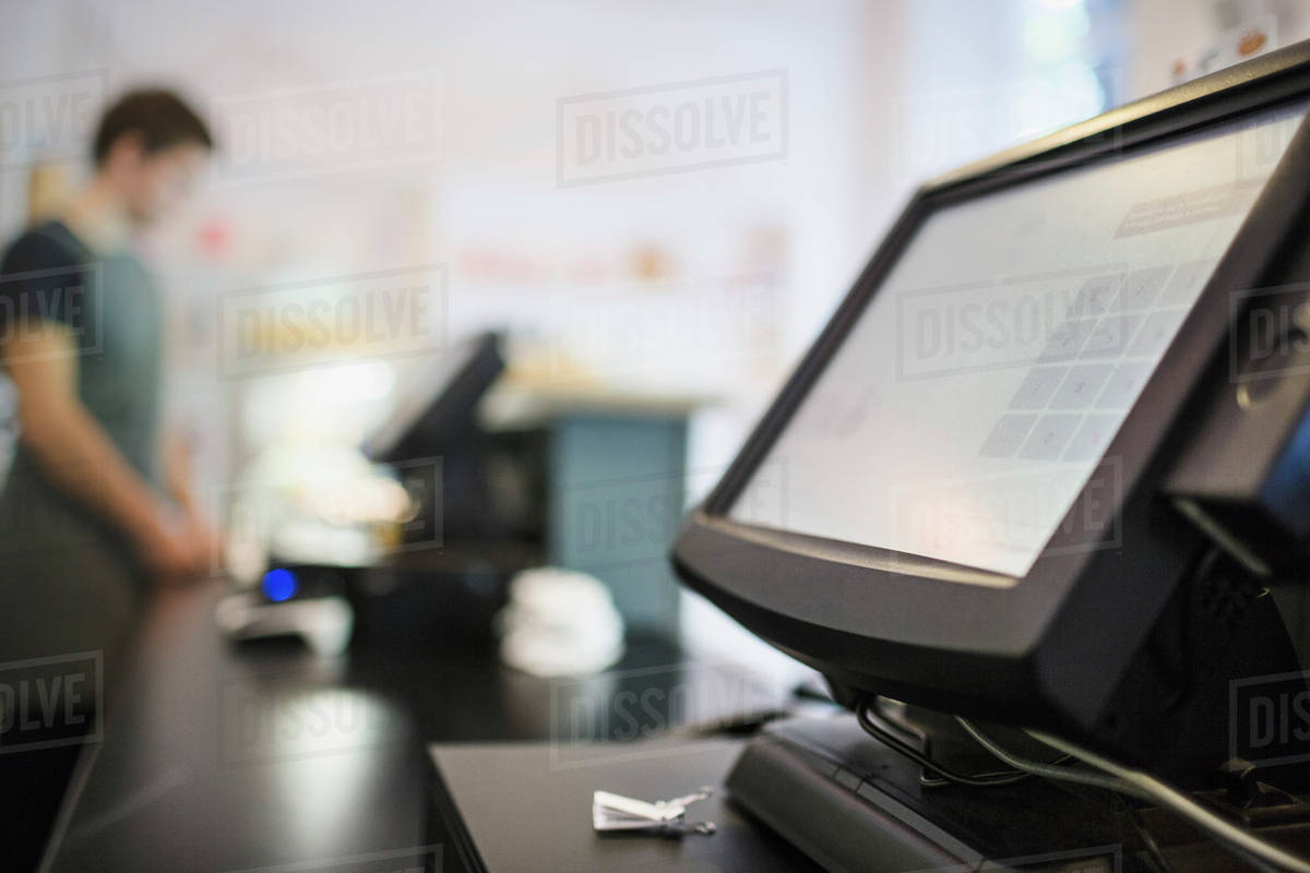 Close Up Of Checkout Counter With Cashier In Background At Coffee