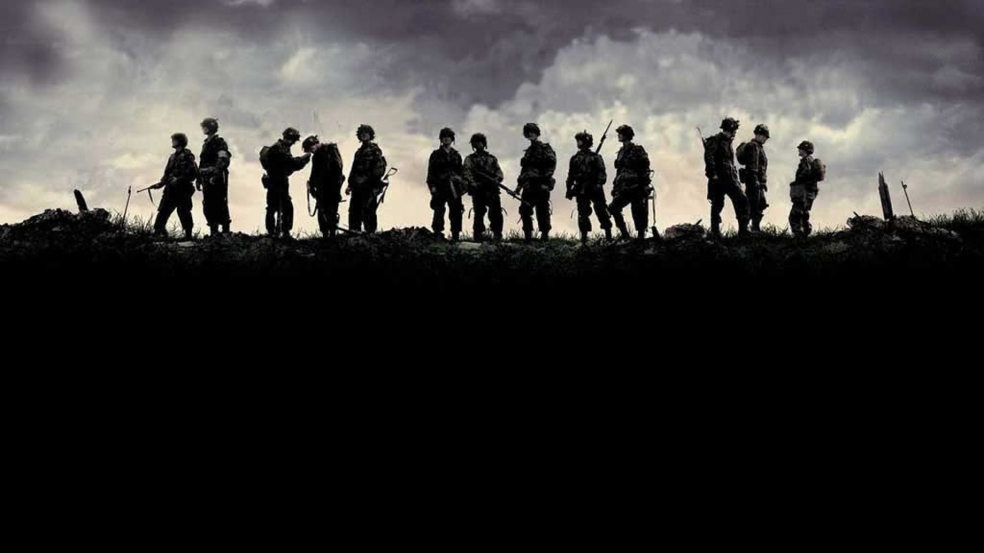 Silhouettes of soldiers against a dramatic sky, evoking themes of war, duty, and camaraderie