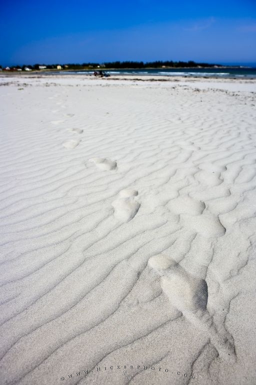 series of footprints in the white sand