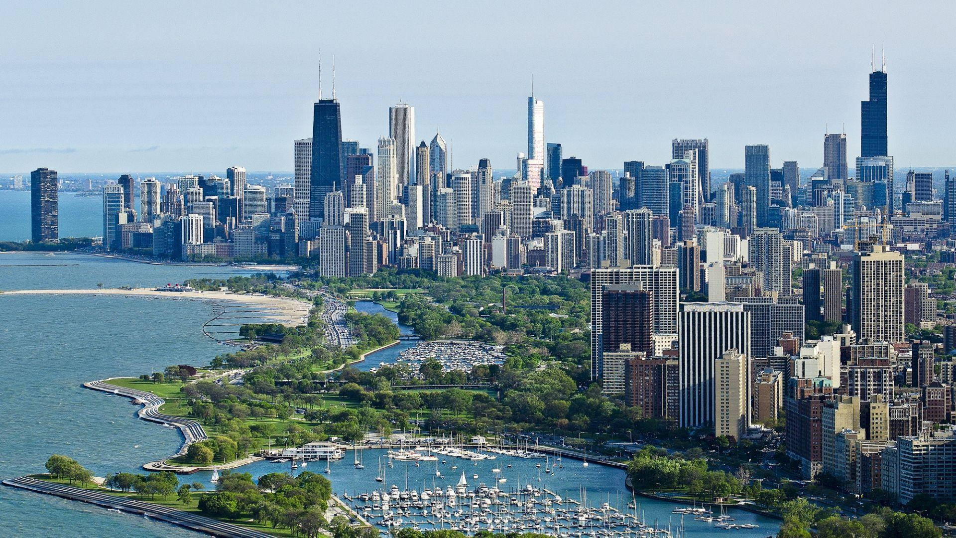 Aerial view of the Chicago skyline on a clear day, featuring Lake Michigan, parks, and skyscrapers