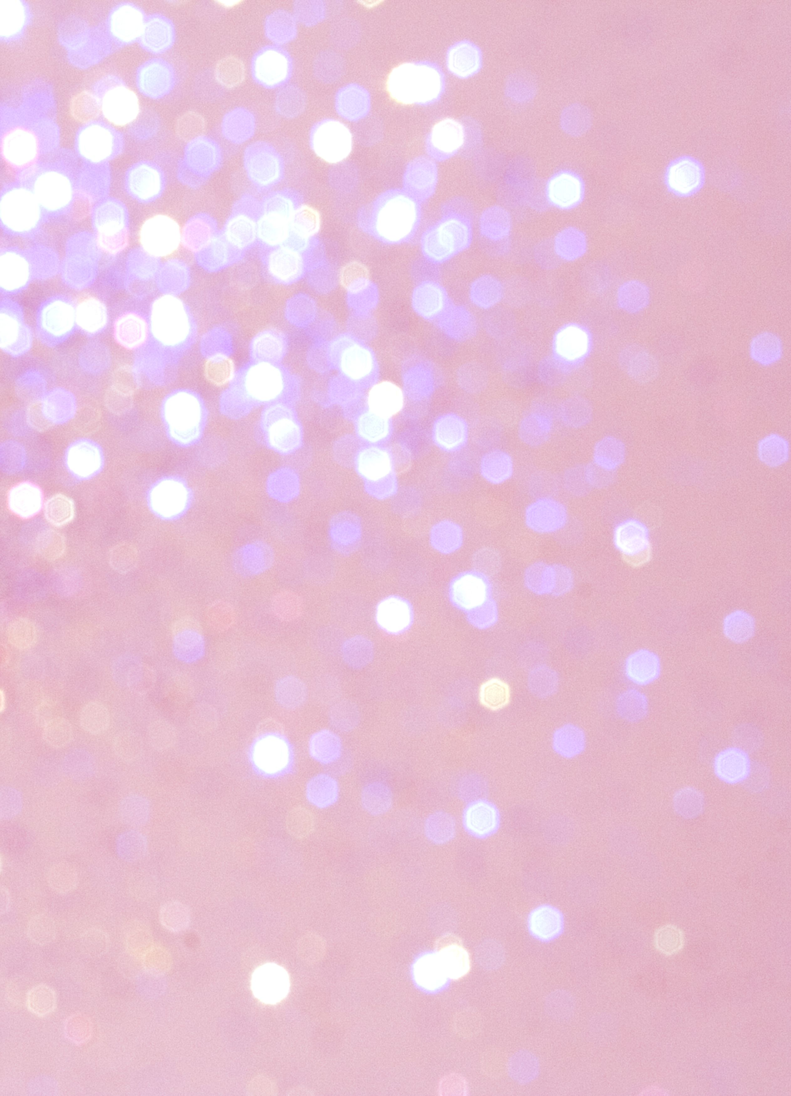 Abstract pink background with sparkling glitter bokeh, creating a dreamy and festive atmosphere