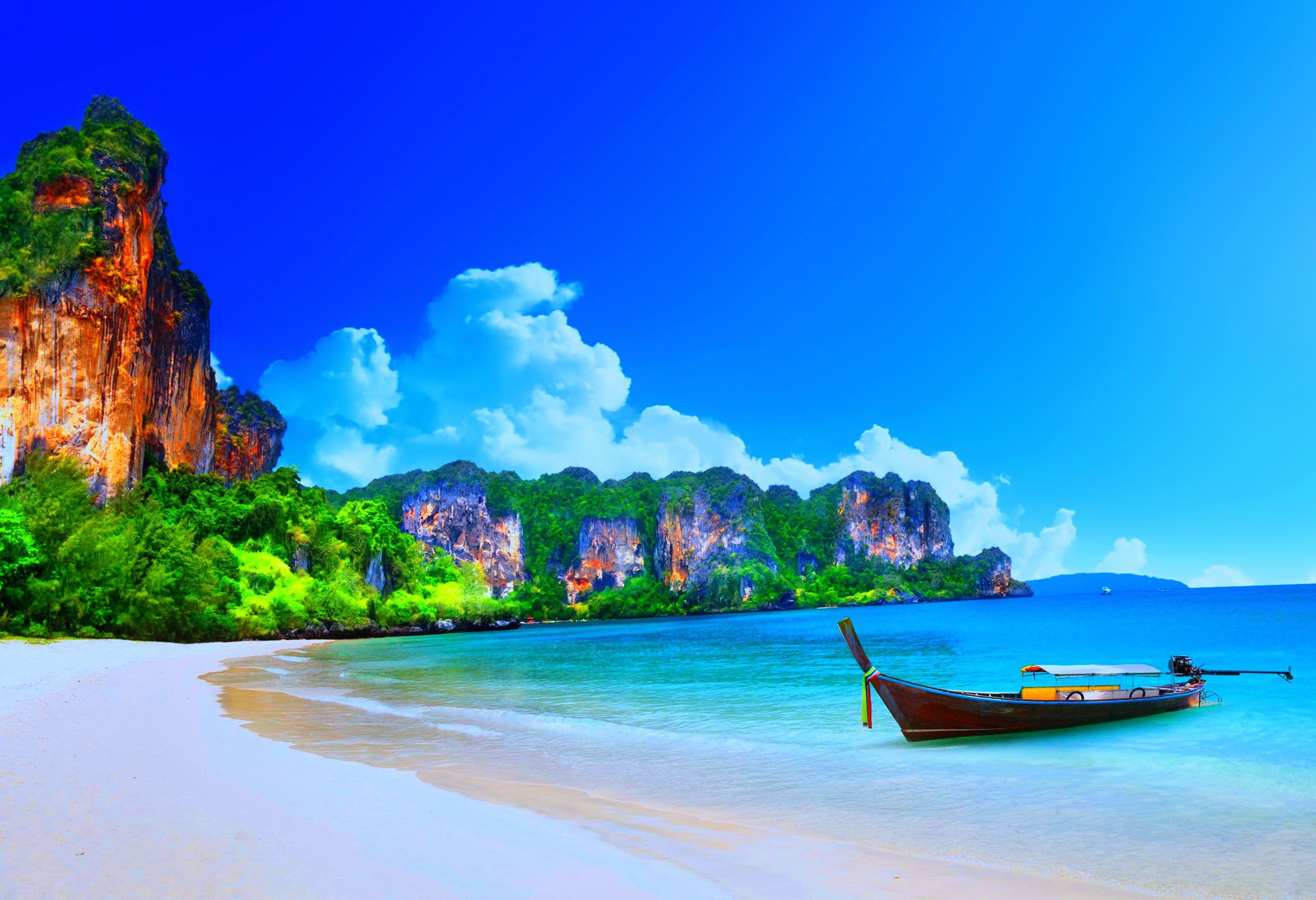There Is A Boat That Sitting On The Beach In Front Of Some Rocks And Water Wallpaper