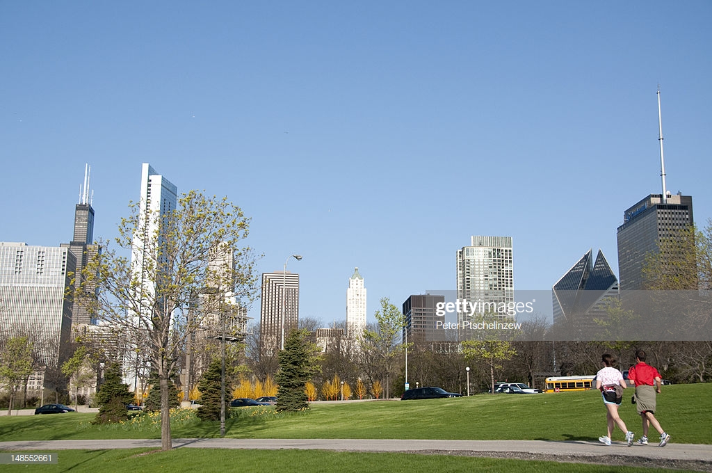 Joggers In Millenium Park With Chicago Skyline Background Stock