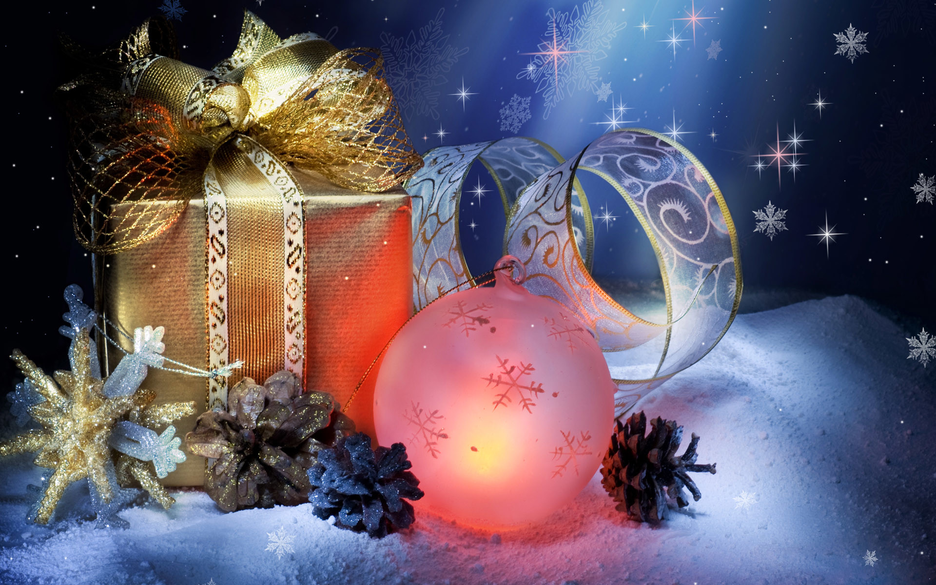 Christmas still life with gift box, glowing ornament, ribbon, pine cones, and snowflakes on snow against a starry night background