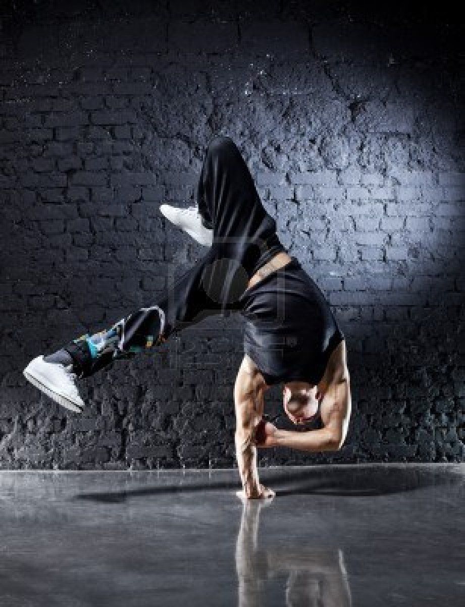 Young Strong Man Break Dance On Dark Wall Background