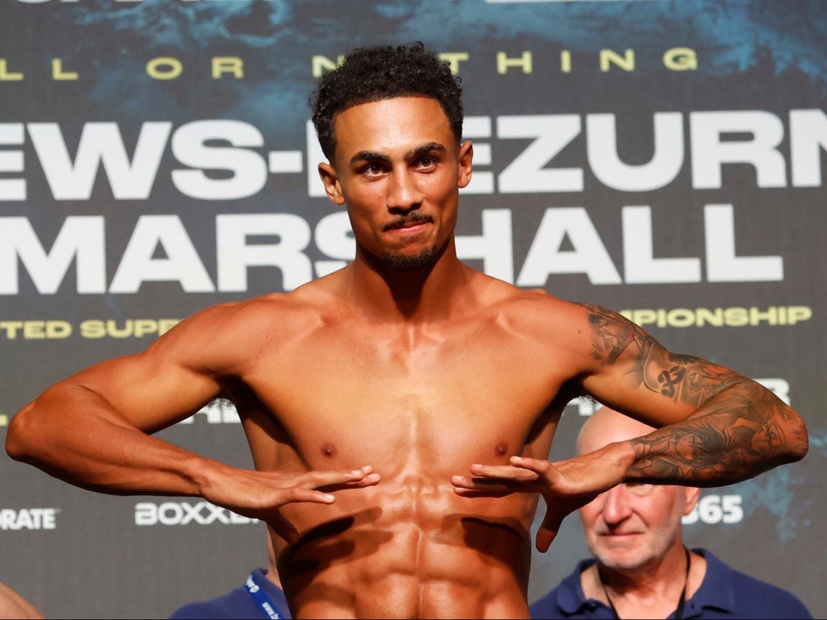 Benjamin Whittaker posing shirtless at a weigh-in, showcasing his physique and tattoos