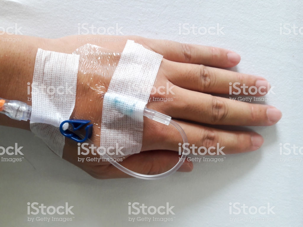 Patient Hand With The Tube Of Normal Saline Infusion On White