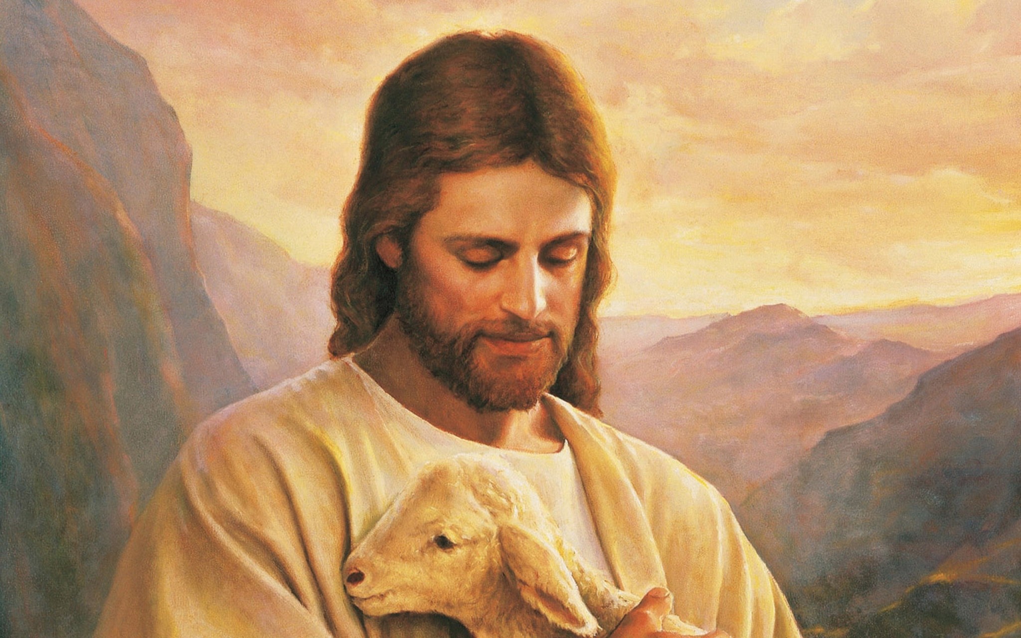 Jesus Christ, the Good Shepherd, gently holds a lamb in his arms, overlooking a serene valley landscape. This image evokes themes of love, compassion, and divine care